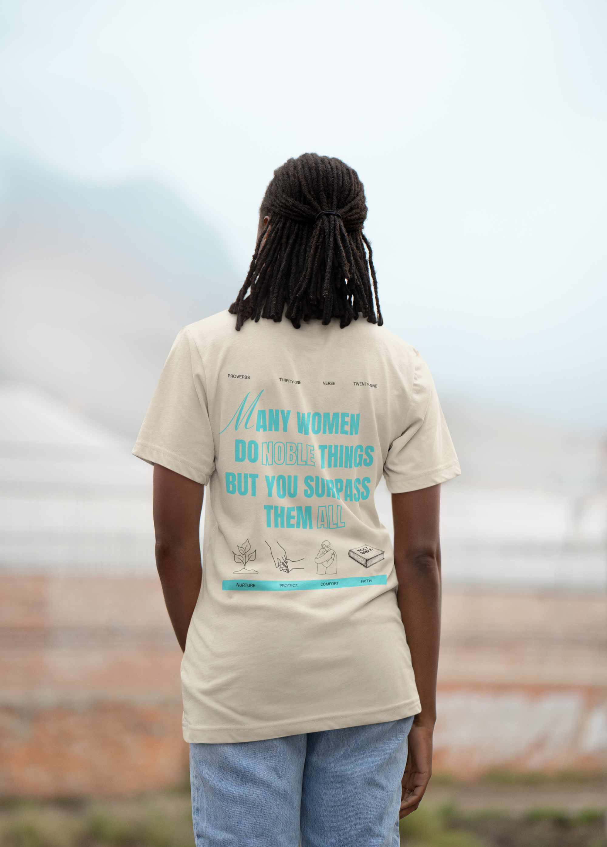 Person with dreadlocks wearing a beige t-shirt with text and illustrations, standing outdoors with a cloudy sky in the background.