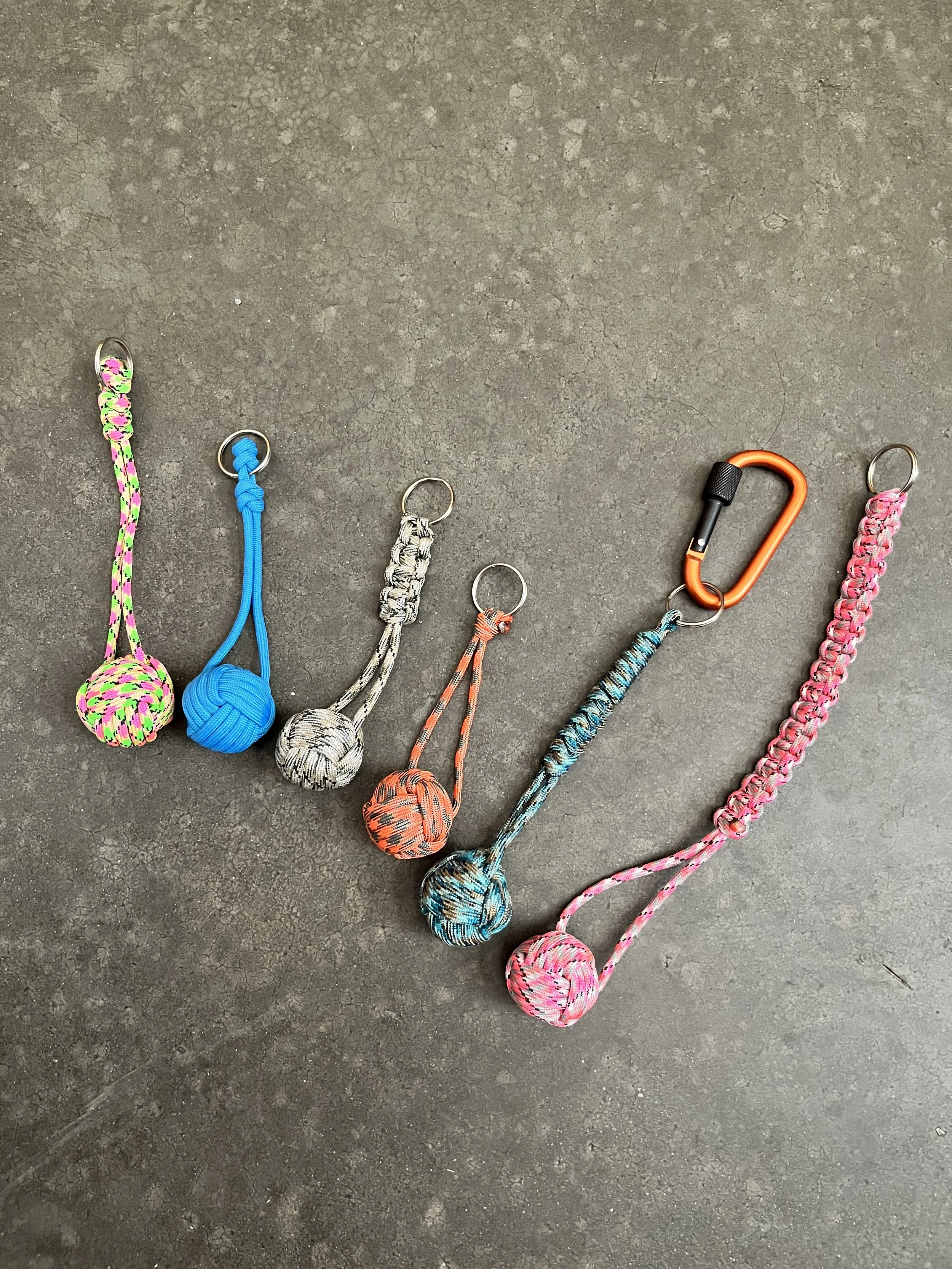 A collection of colorful paracord emergeny keychains.