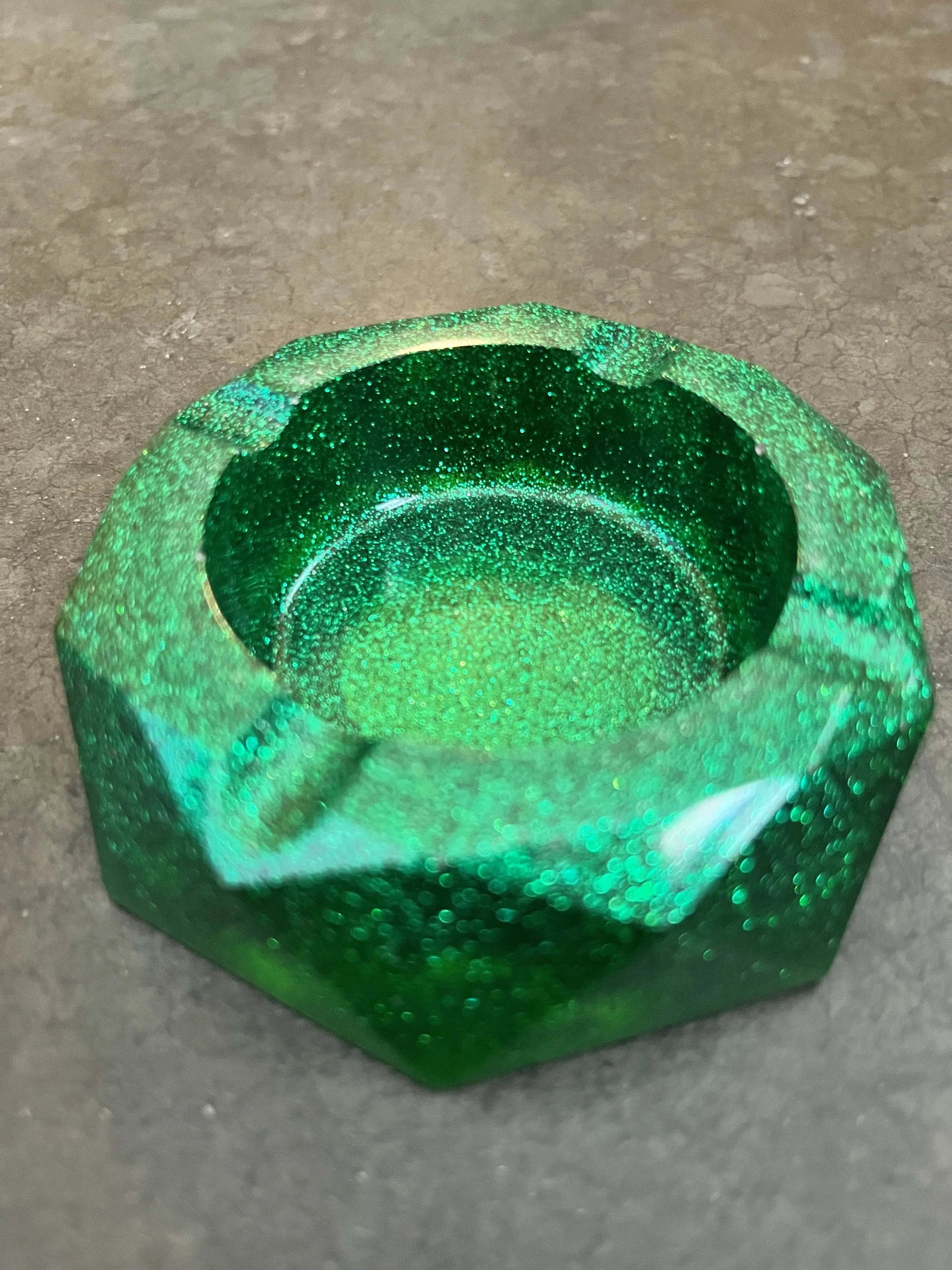 A handmade glowing green glittery resin epoxy ashtray/bowl.