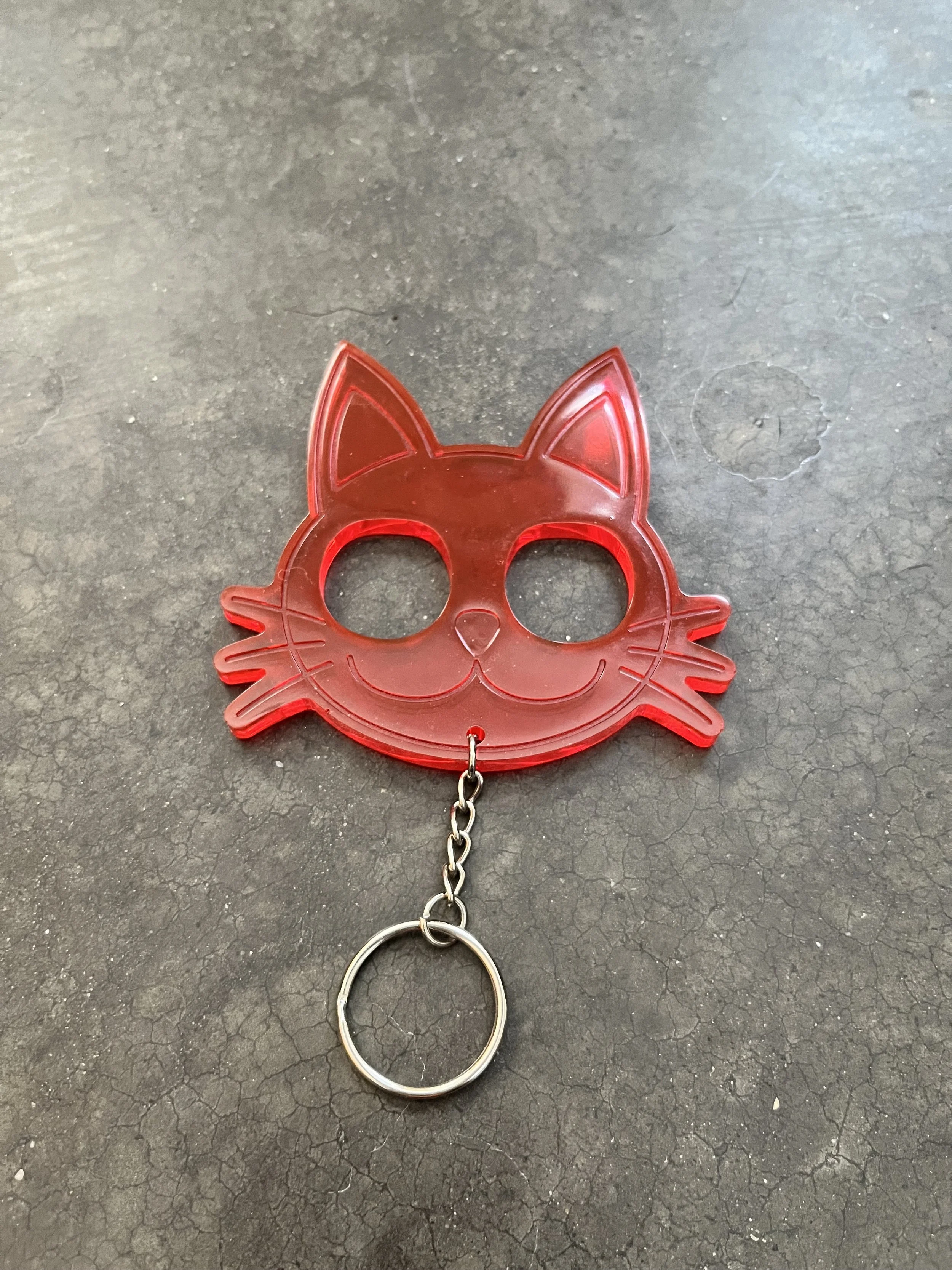A handmade red, cat-shaped resin epoxy emergency keychain.