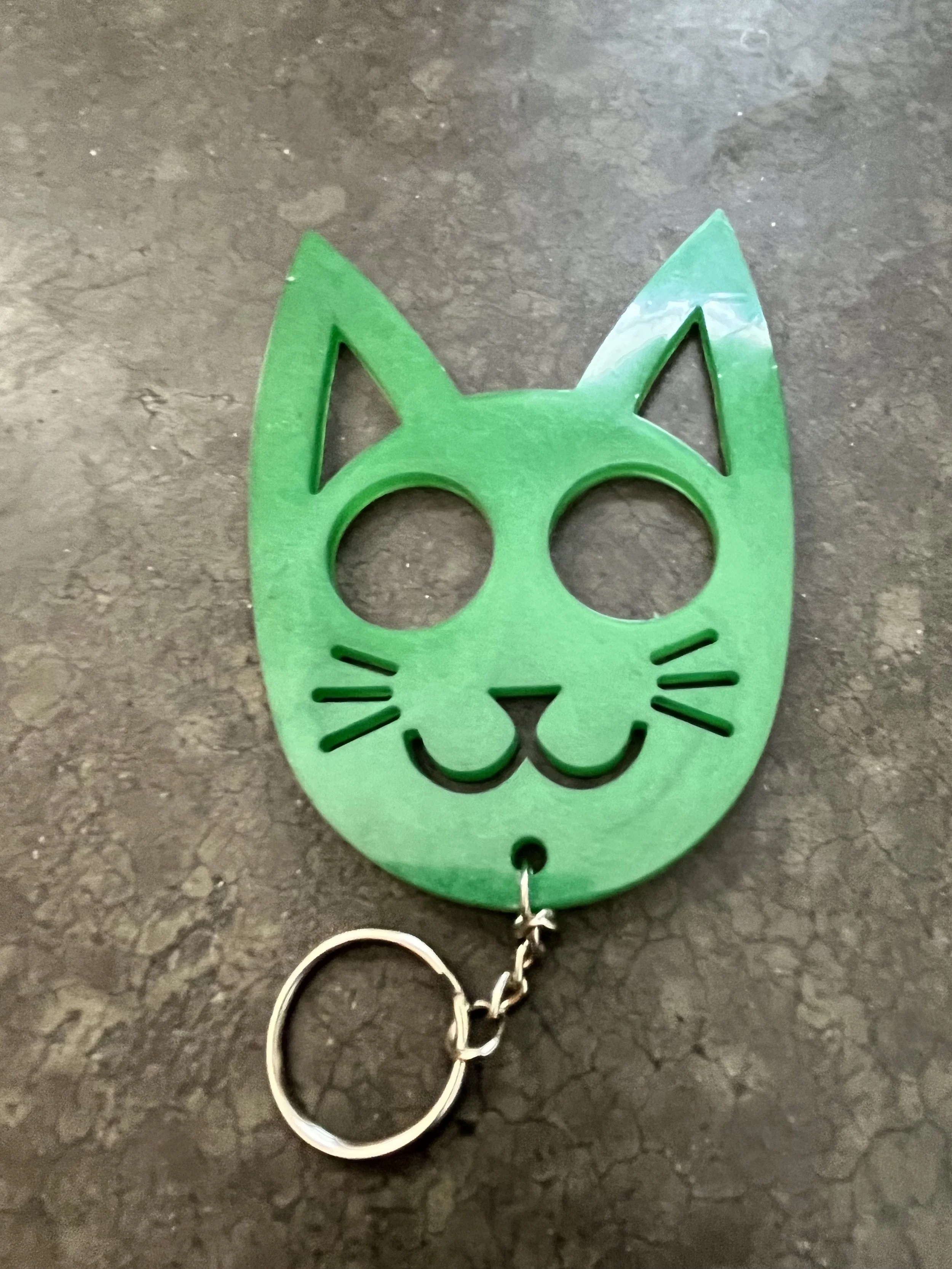A handmade green cat-shaped resin epoxy emergency keychain.