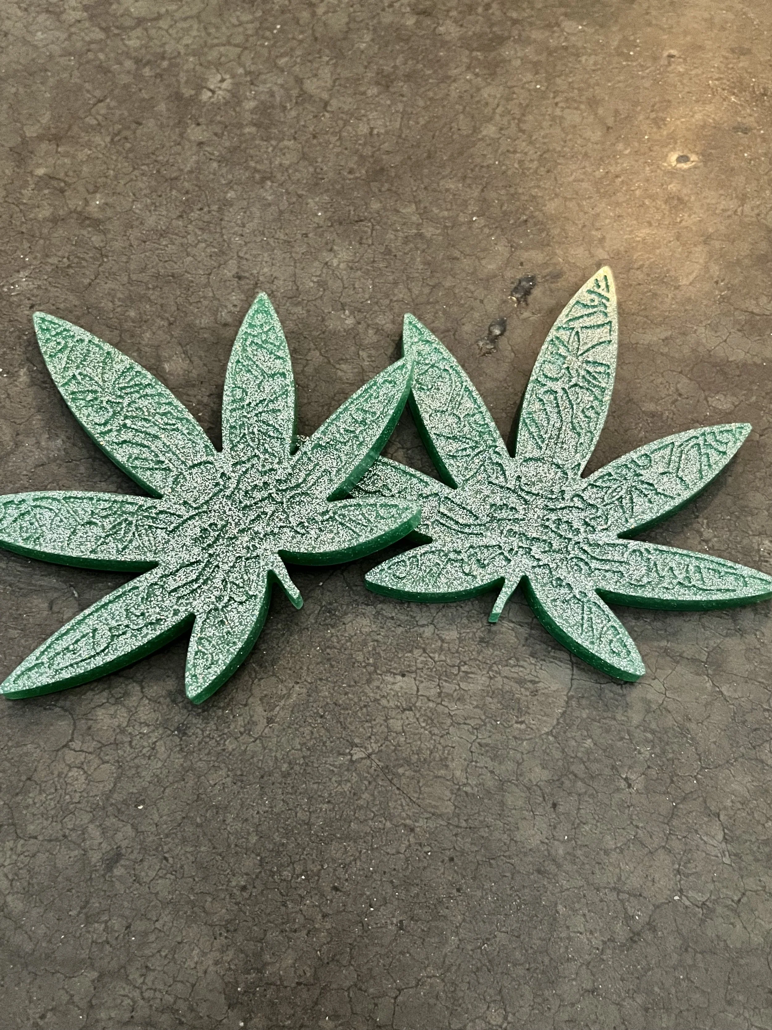 Two glittery green marijuana coasters.