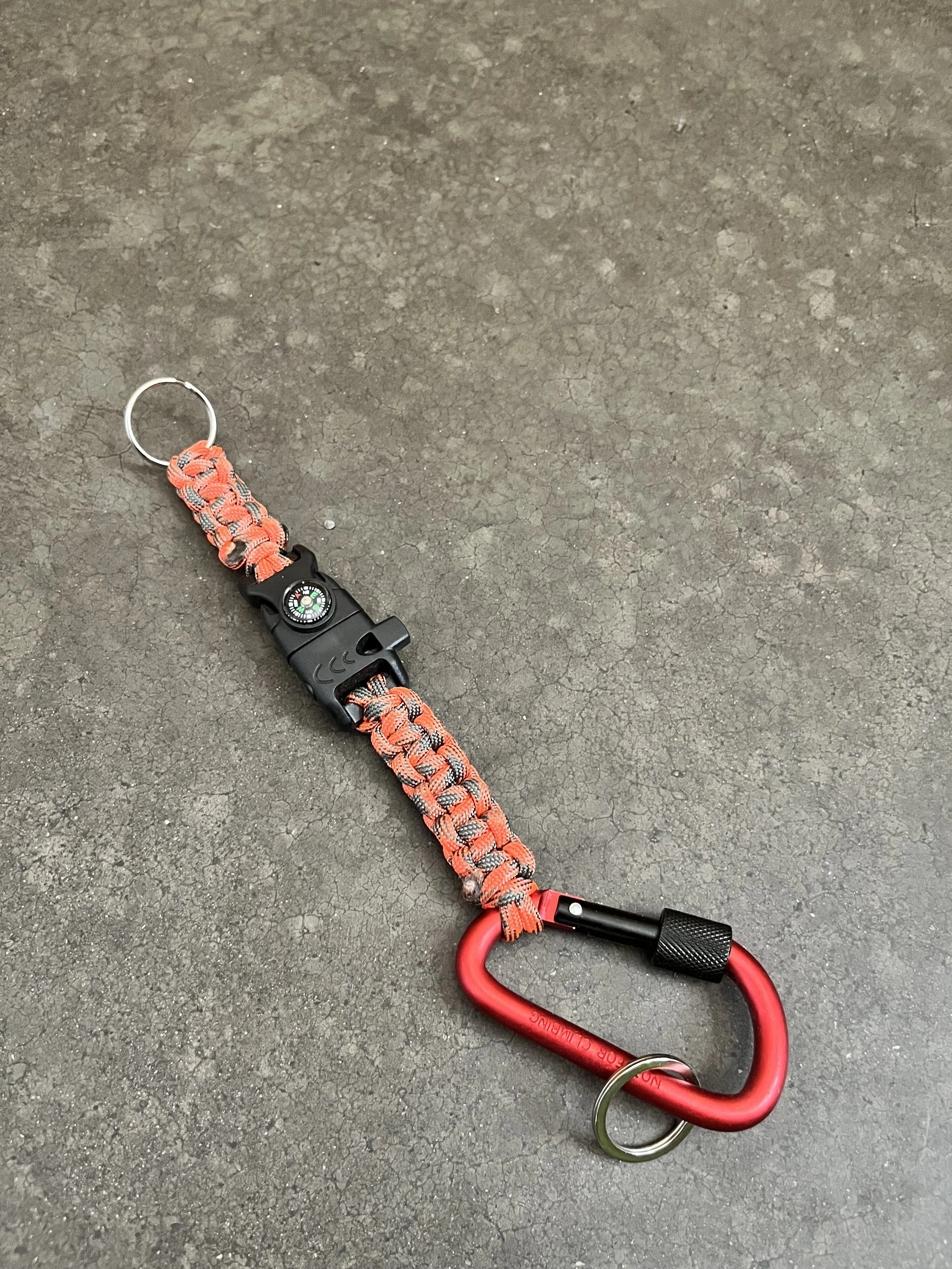 A carabiner with paracord and compass.