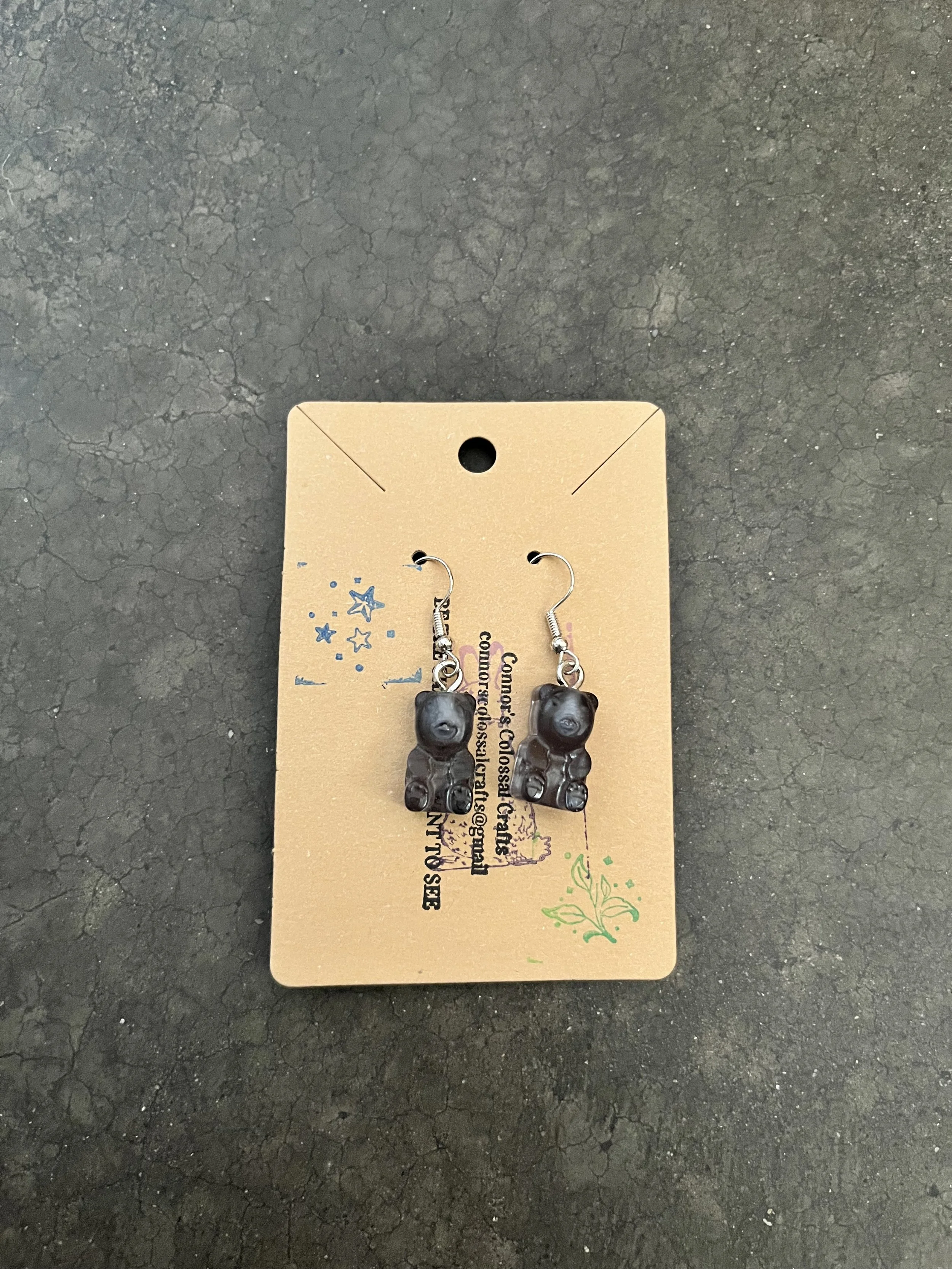 A handmade pair of dark gummy bear earrings.