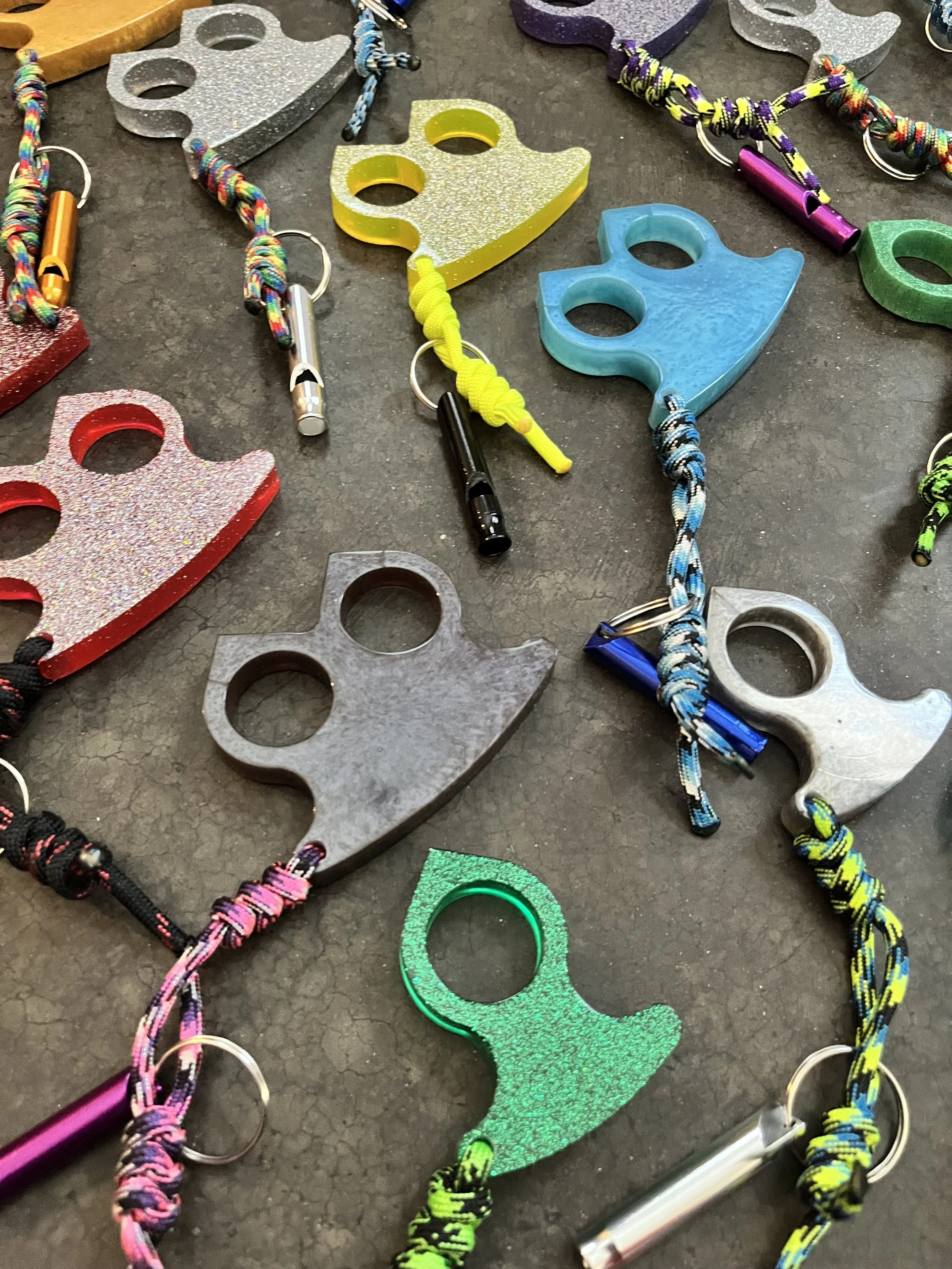 Colorful climbing holds and ropes arranged on a dark, textured surface.