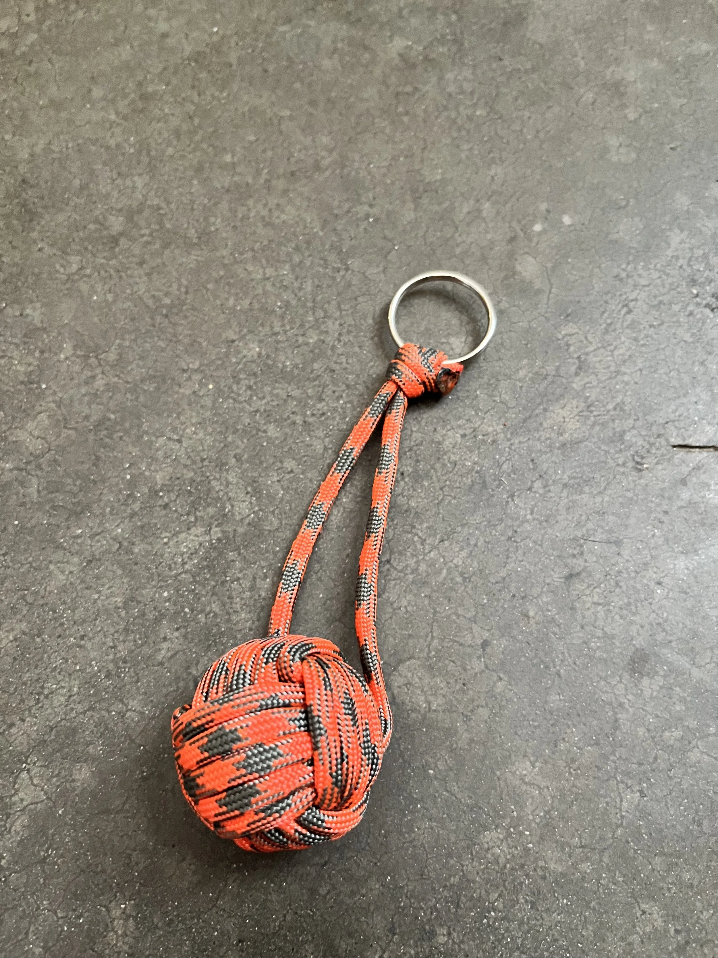 An orange and gray emergency ball keychain.
