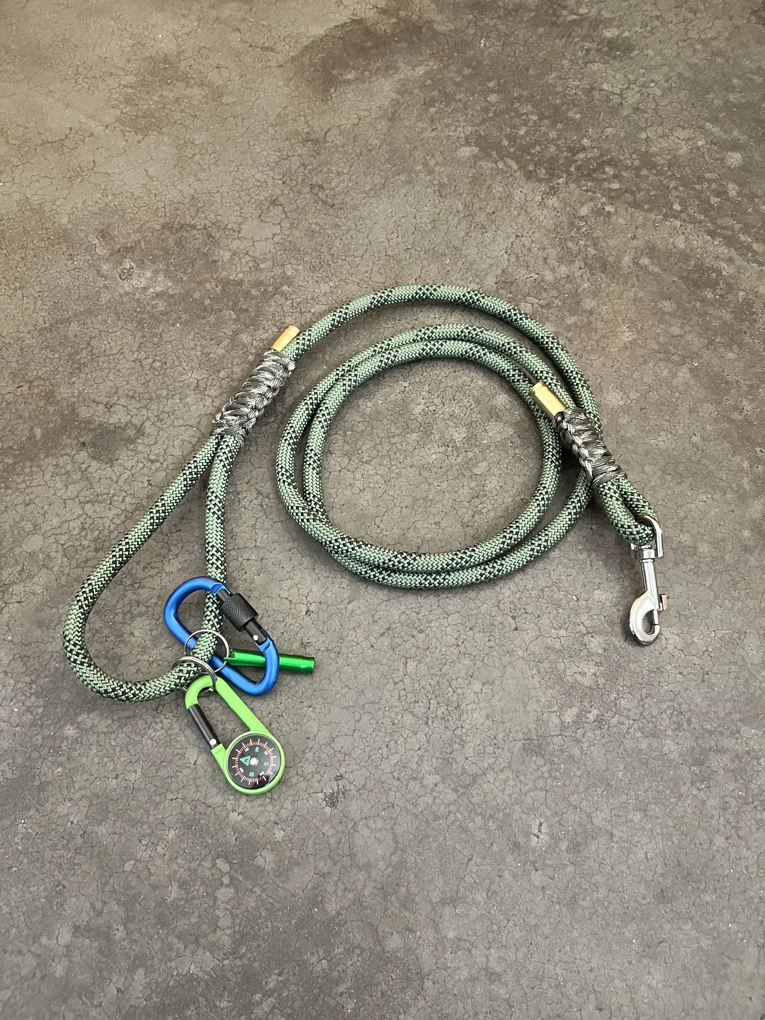 A handmade coiled green and black braided rope/paracord dog leash.