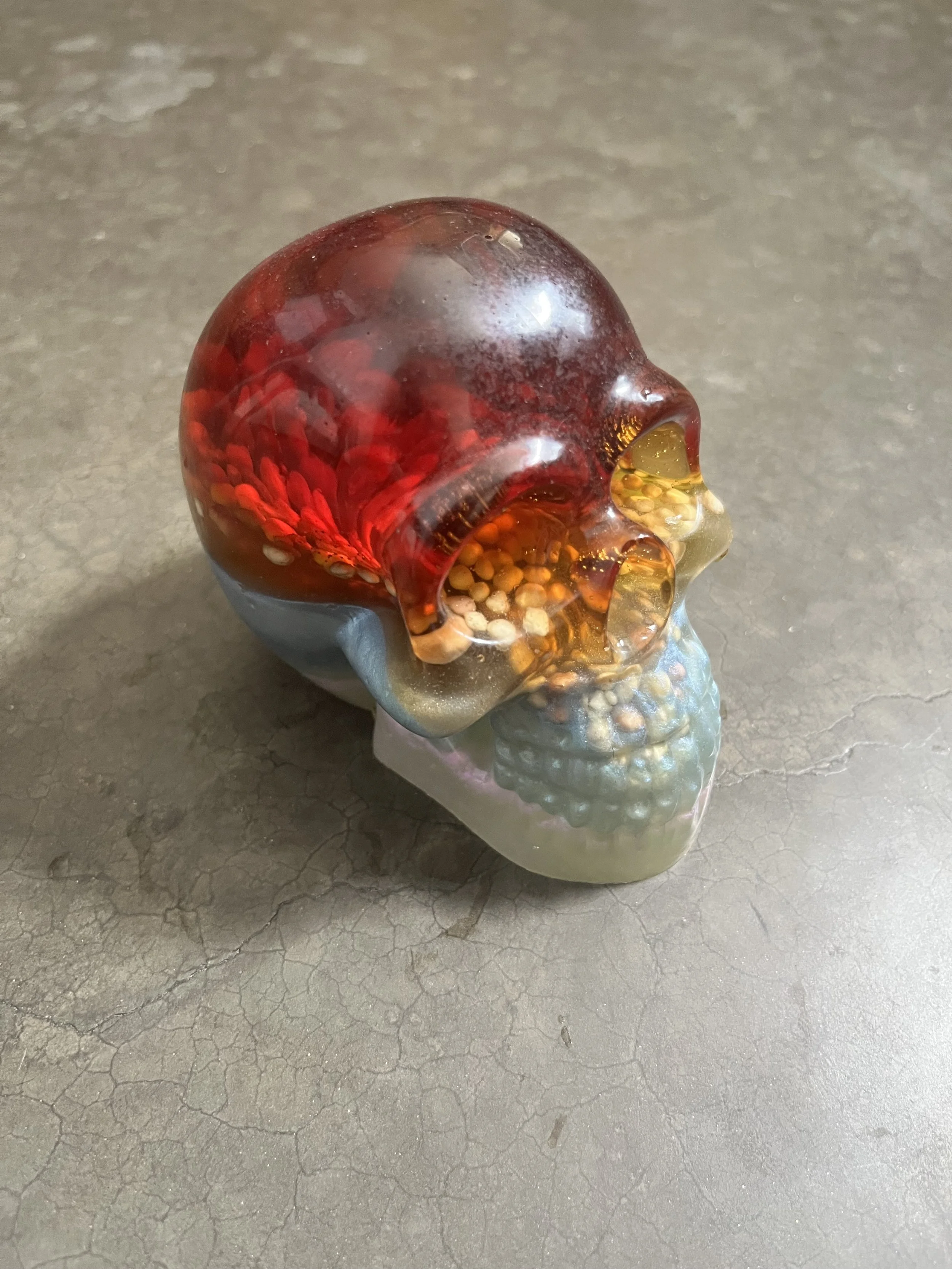 An epoxy resin skull on a cracked concrete surface.