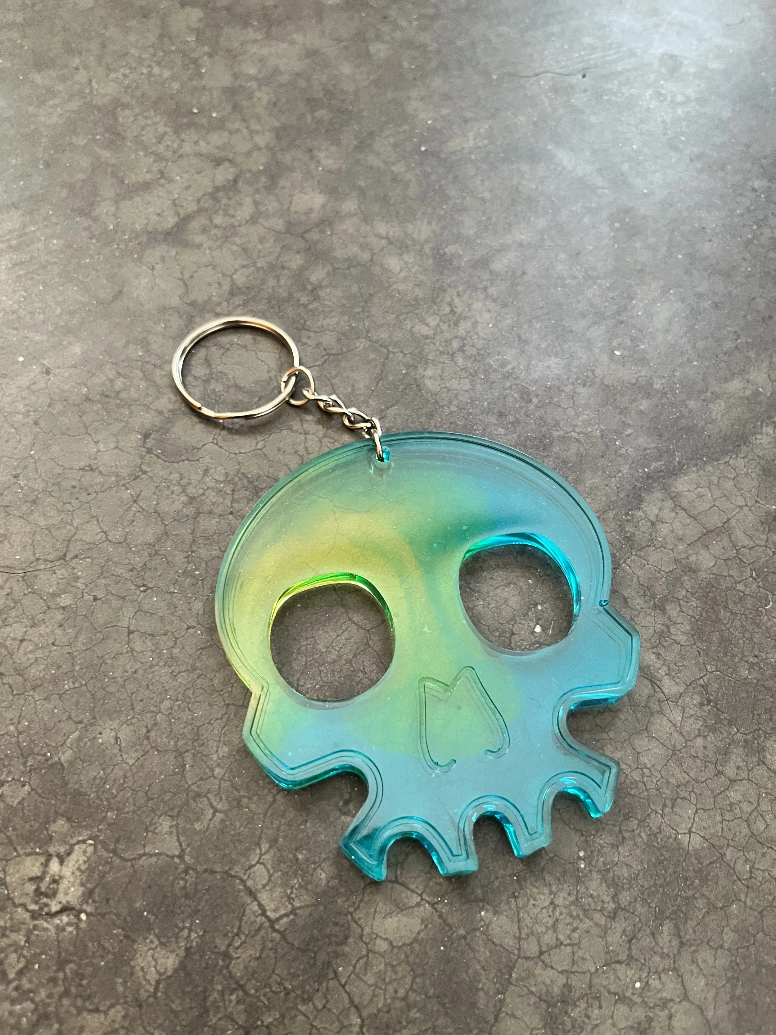 A handmade blue and yellow skull resin epoxy emergency keychain.