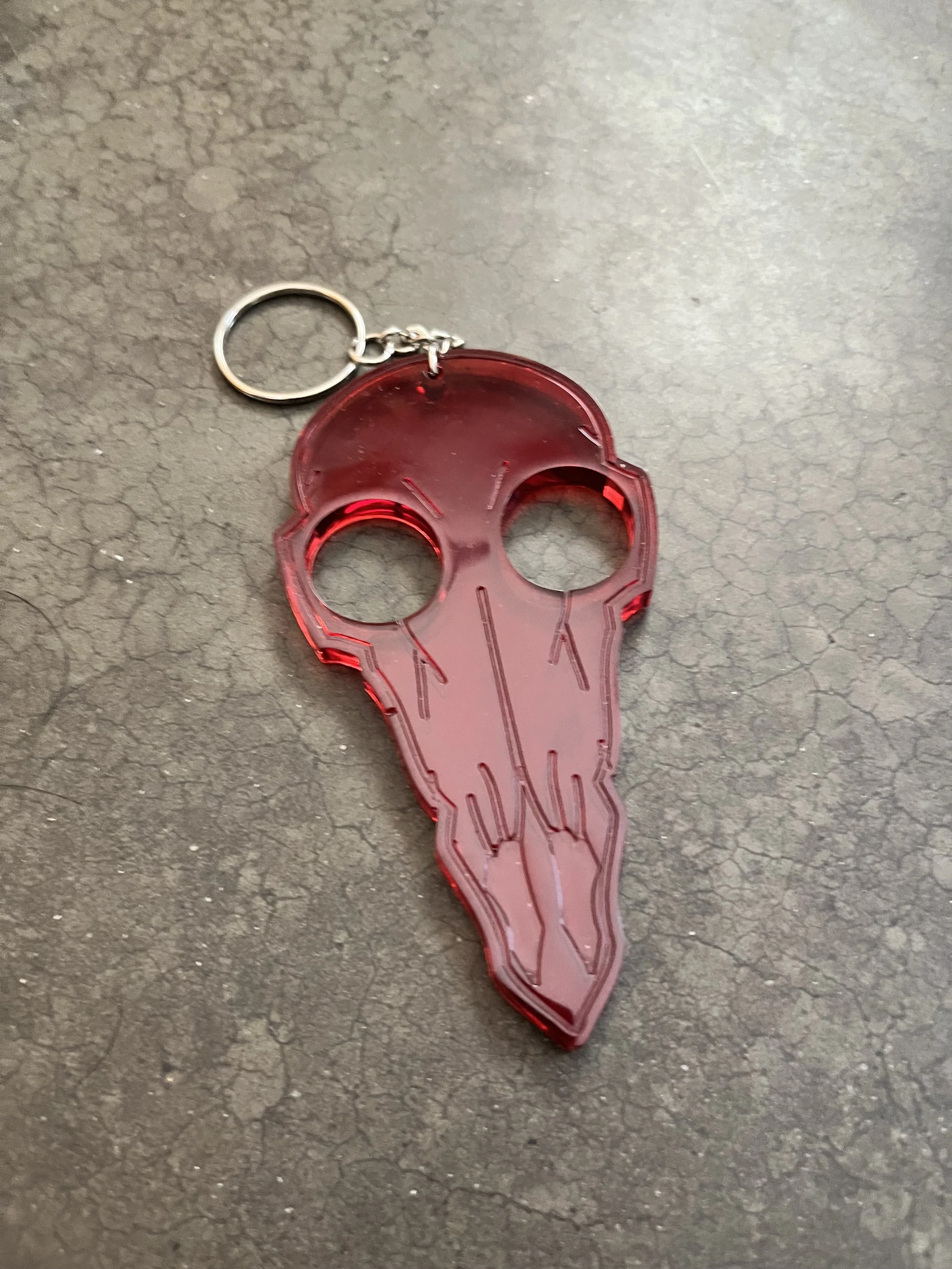 A red keychain shaped like a birds skull.