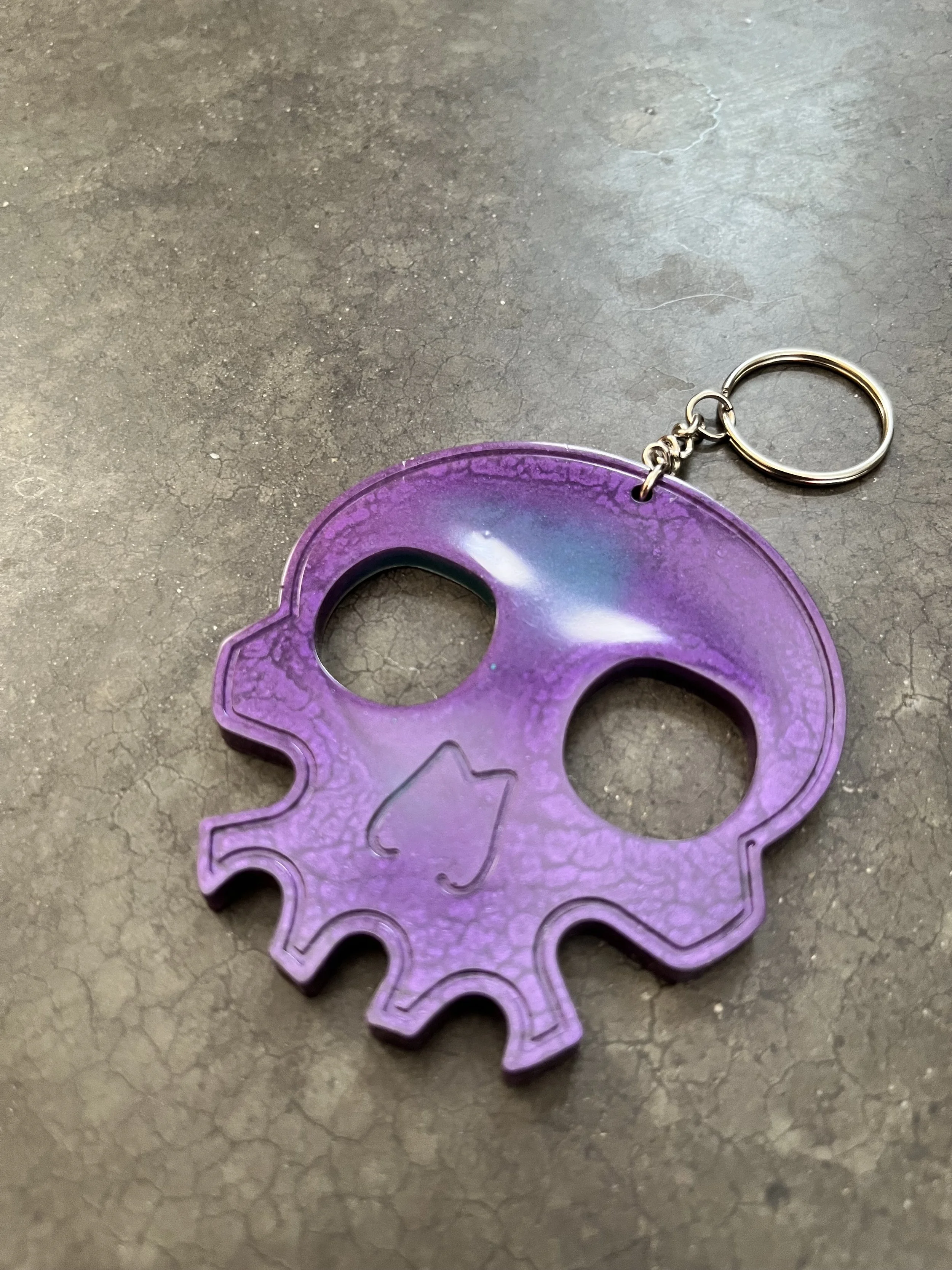 A purple keychain in the shape of a skull.