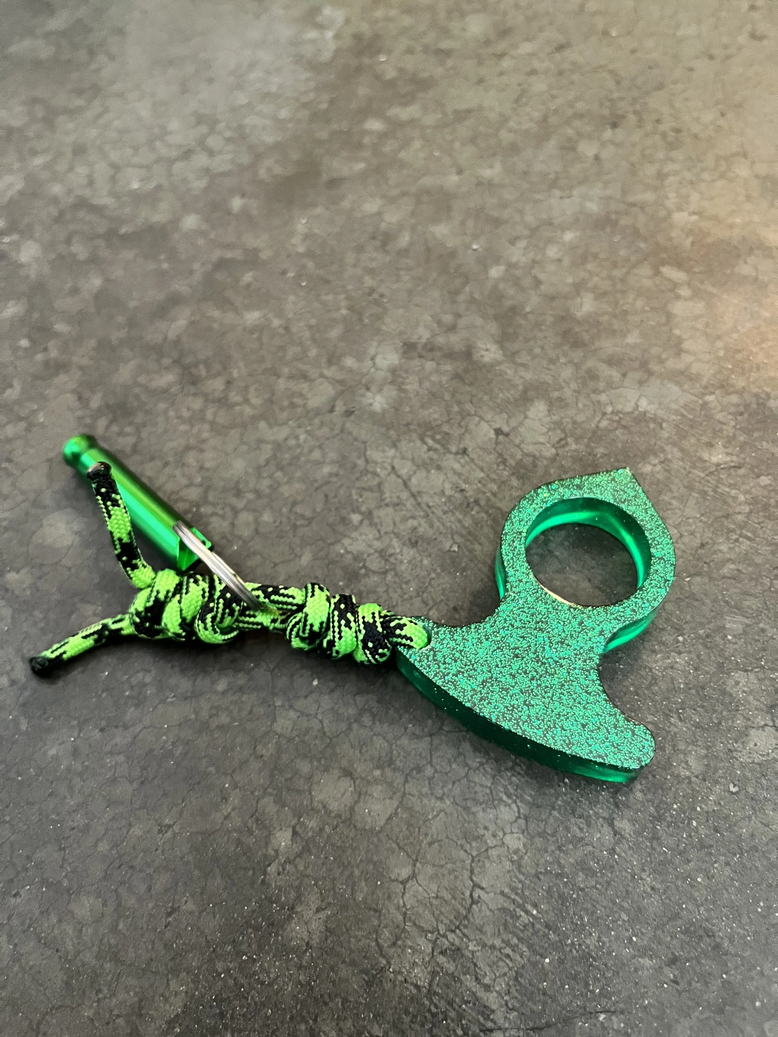 A handmade paracord green glittery resin epoxy emergency keychain.