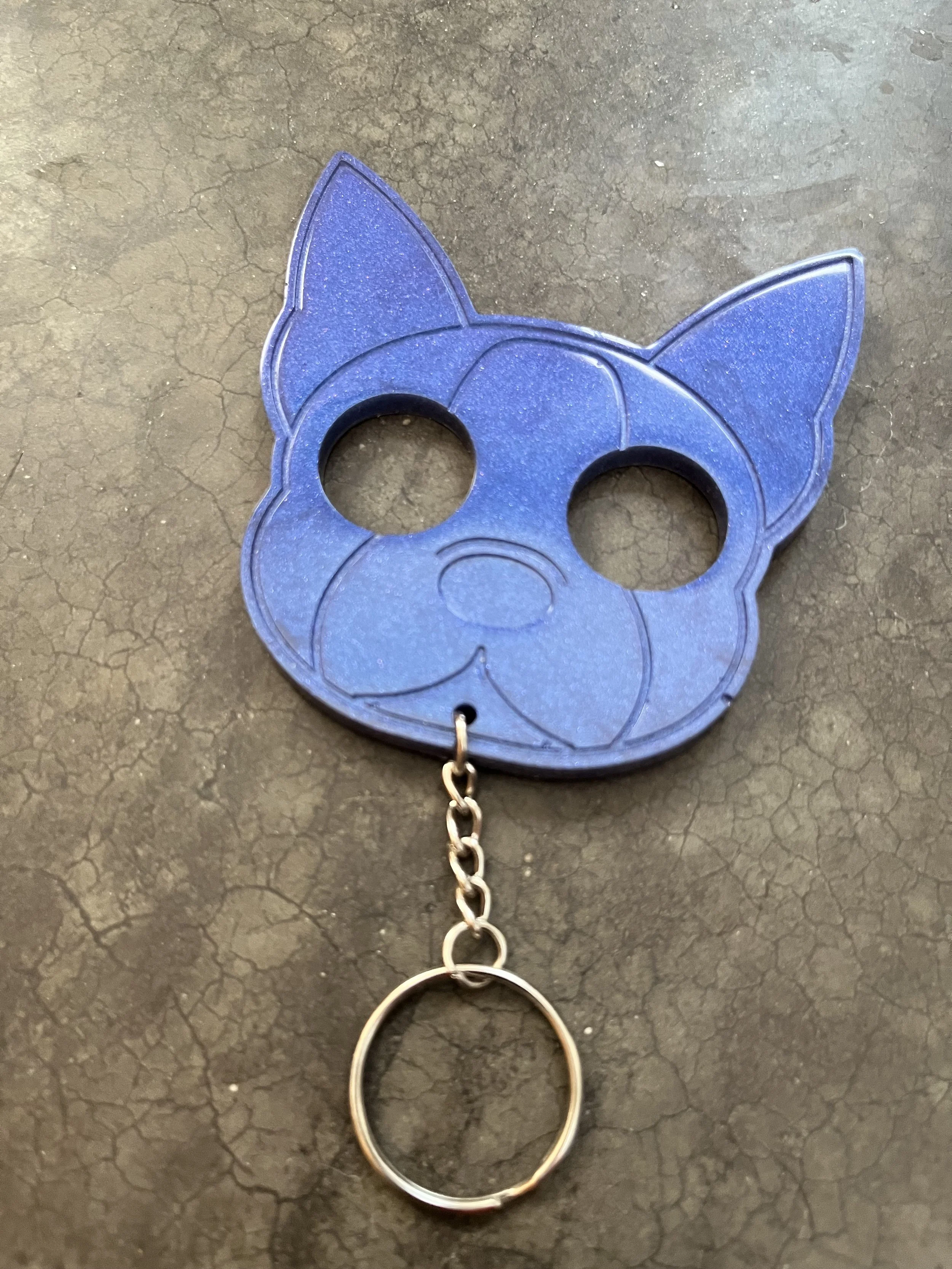 A blue handmade epoxy resin emergency keychain.