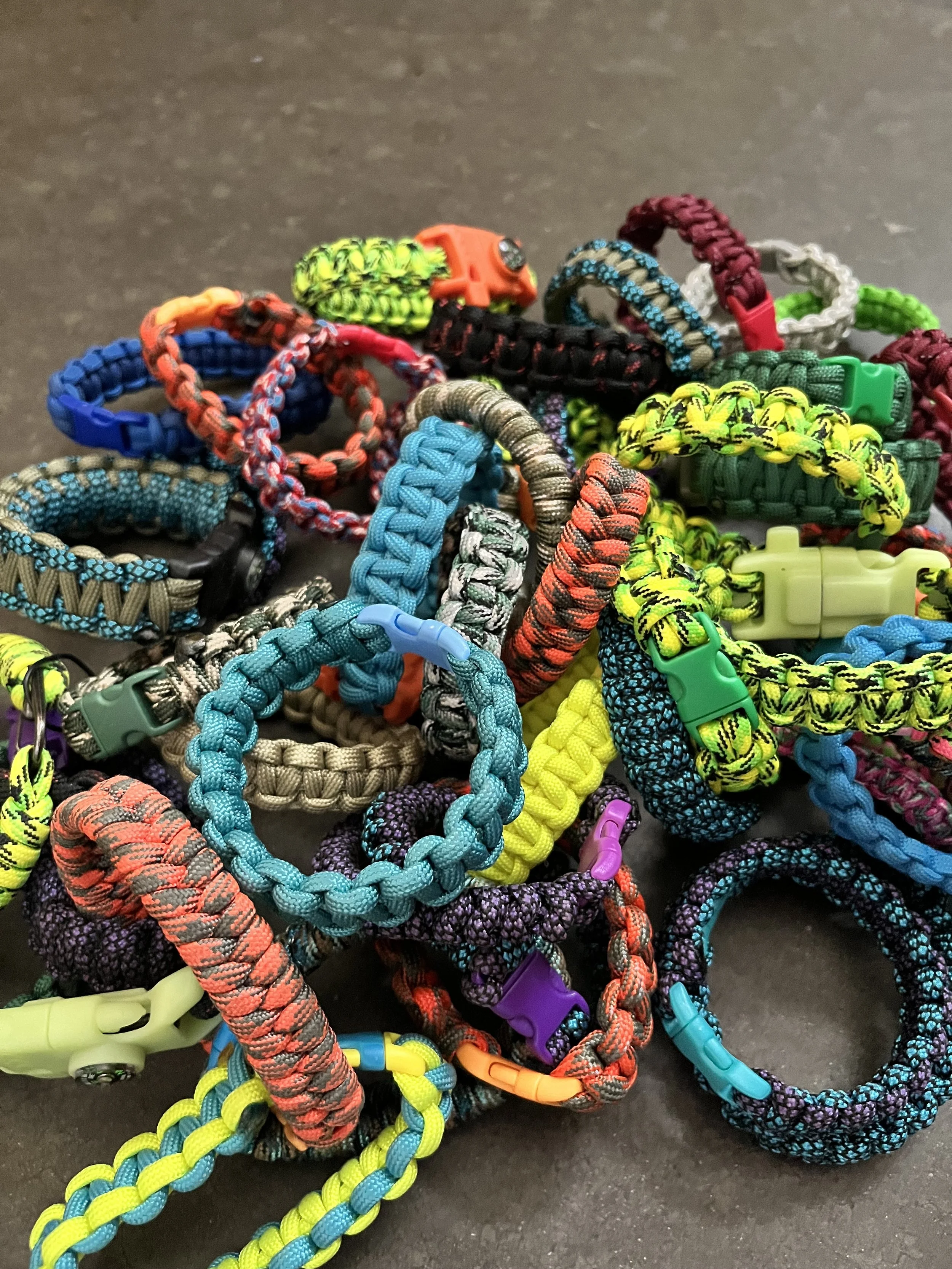 A collection of colorful handmade paracord bracelets.