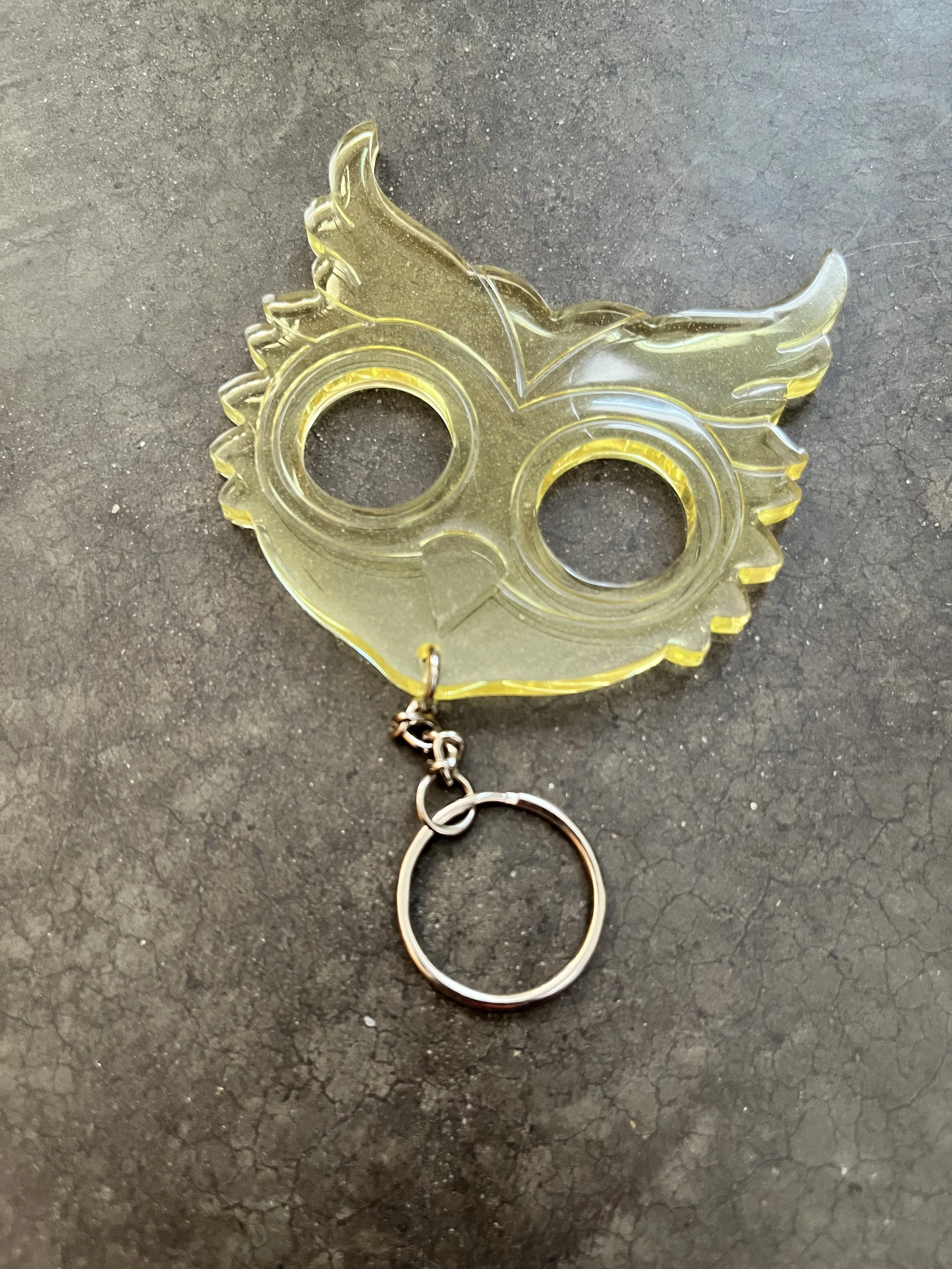 A handmade clear yellow resin epoxy emergency keychain.