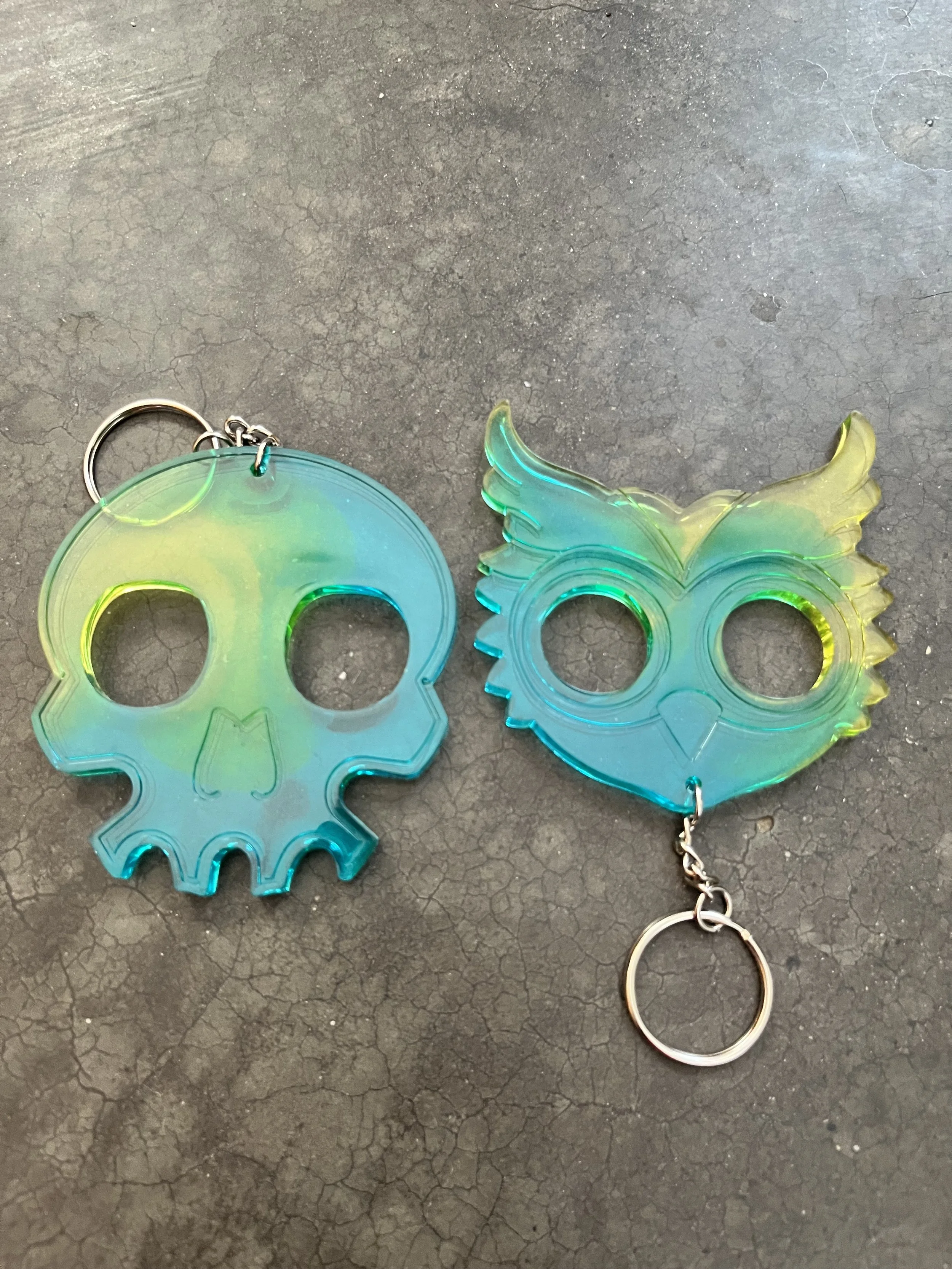 Two handmade blue and yellow resin epoxy emergency keychains.
