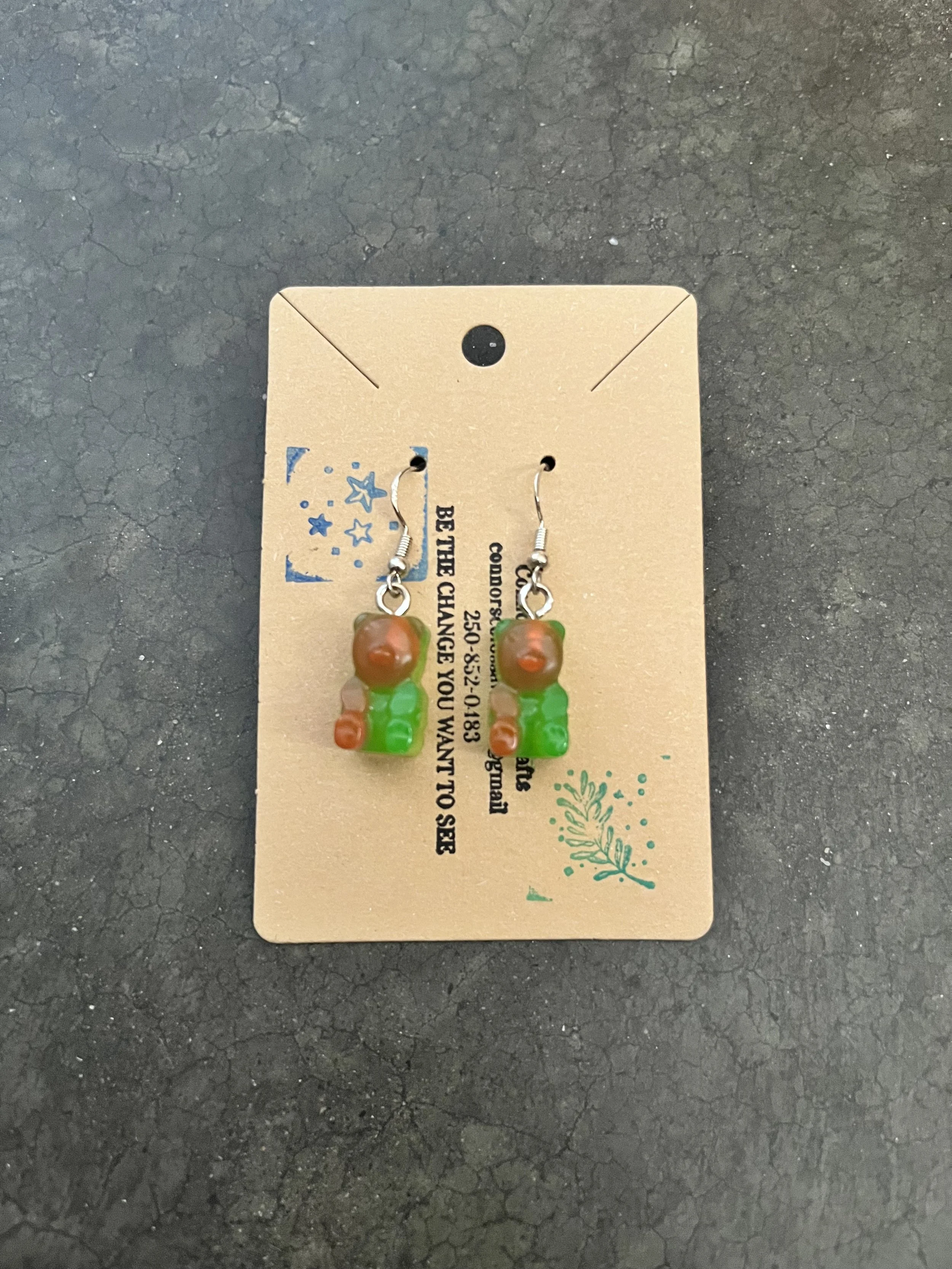 A handmade pair of green and pink gummy bear earrings.