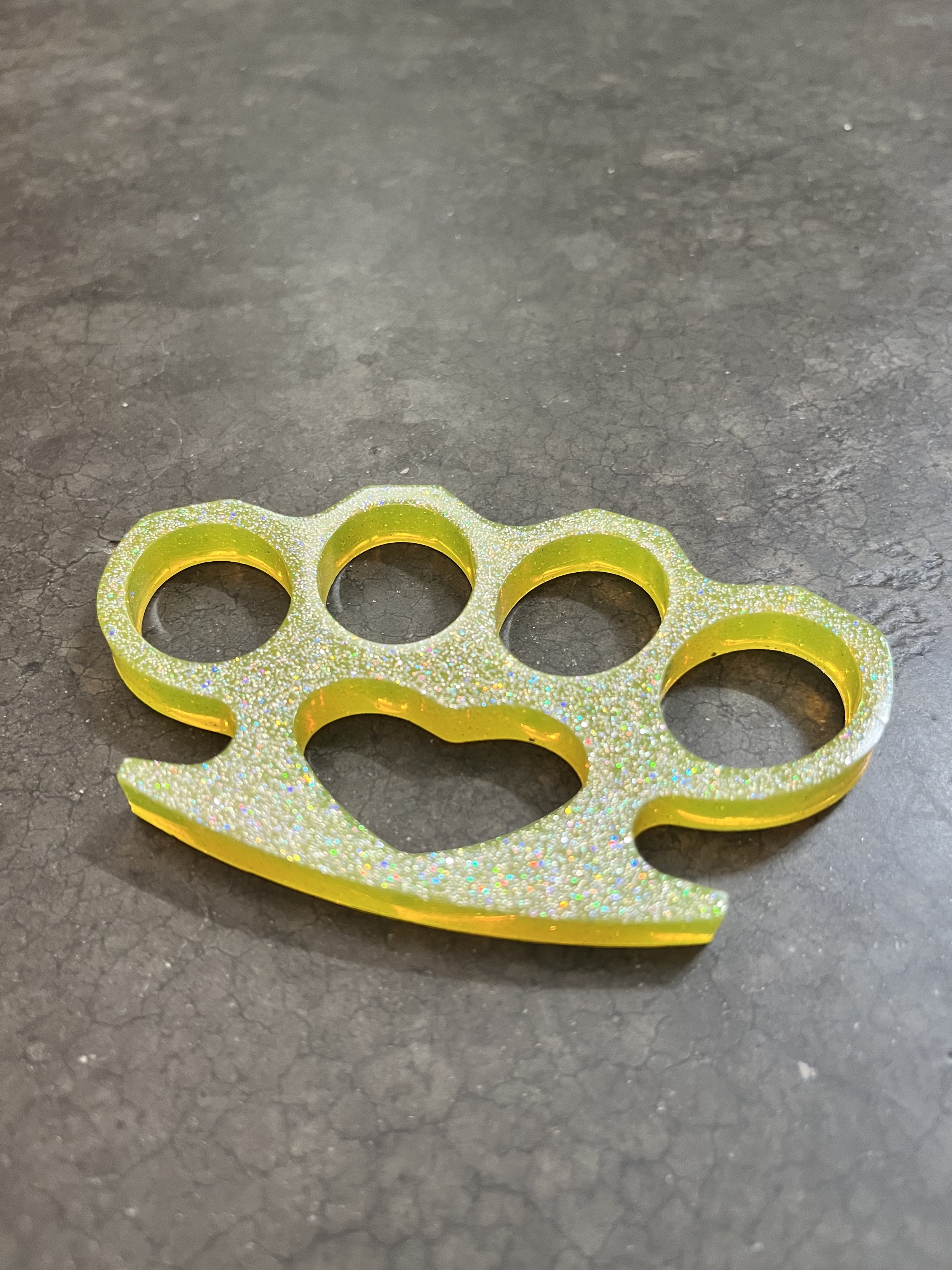A glittery yellow resin epoxy emergency knuckle keychain.Totally Legal.