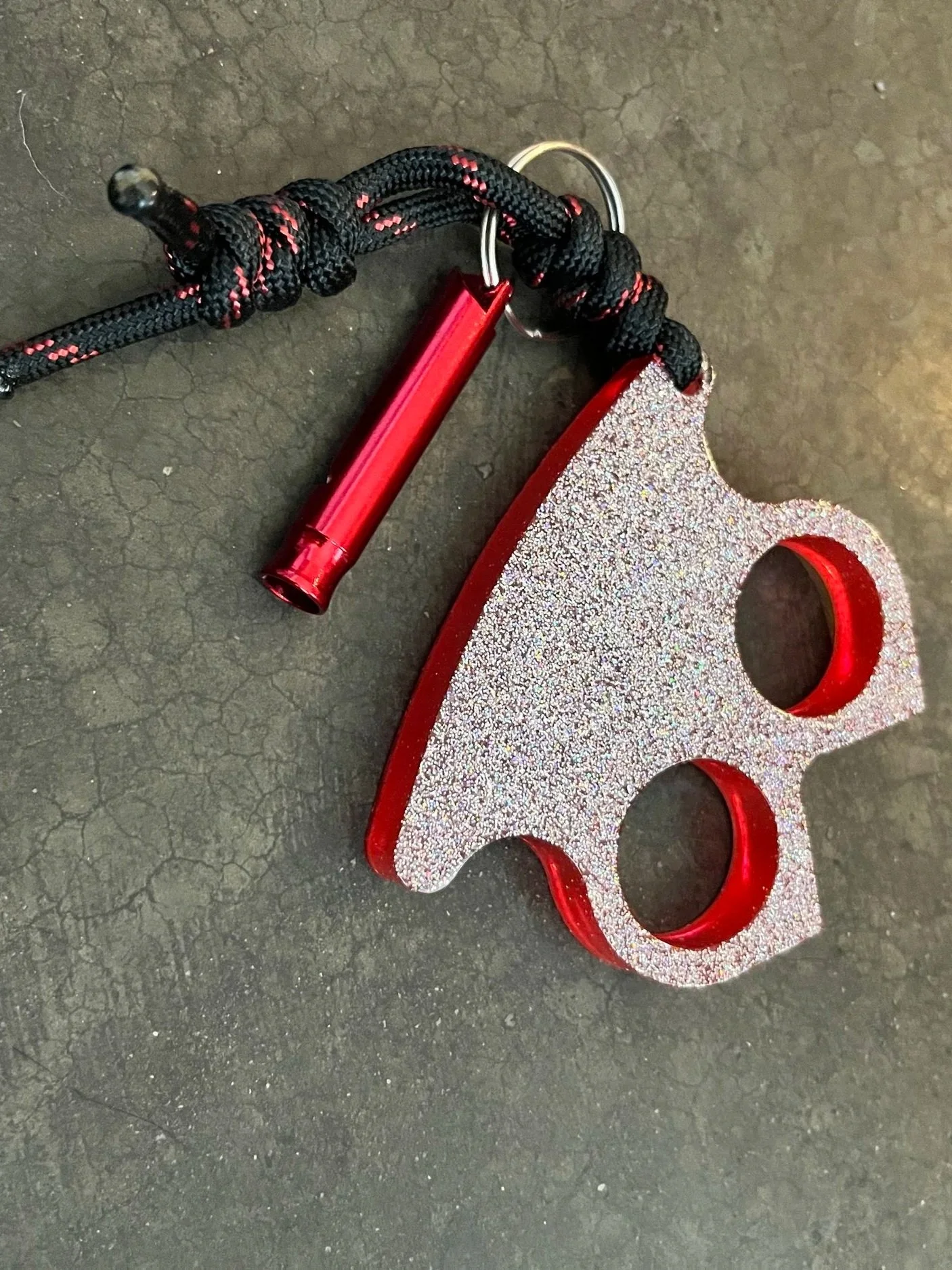 Handmade red and glittery resin epoxy emergency keychain with paracord.
