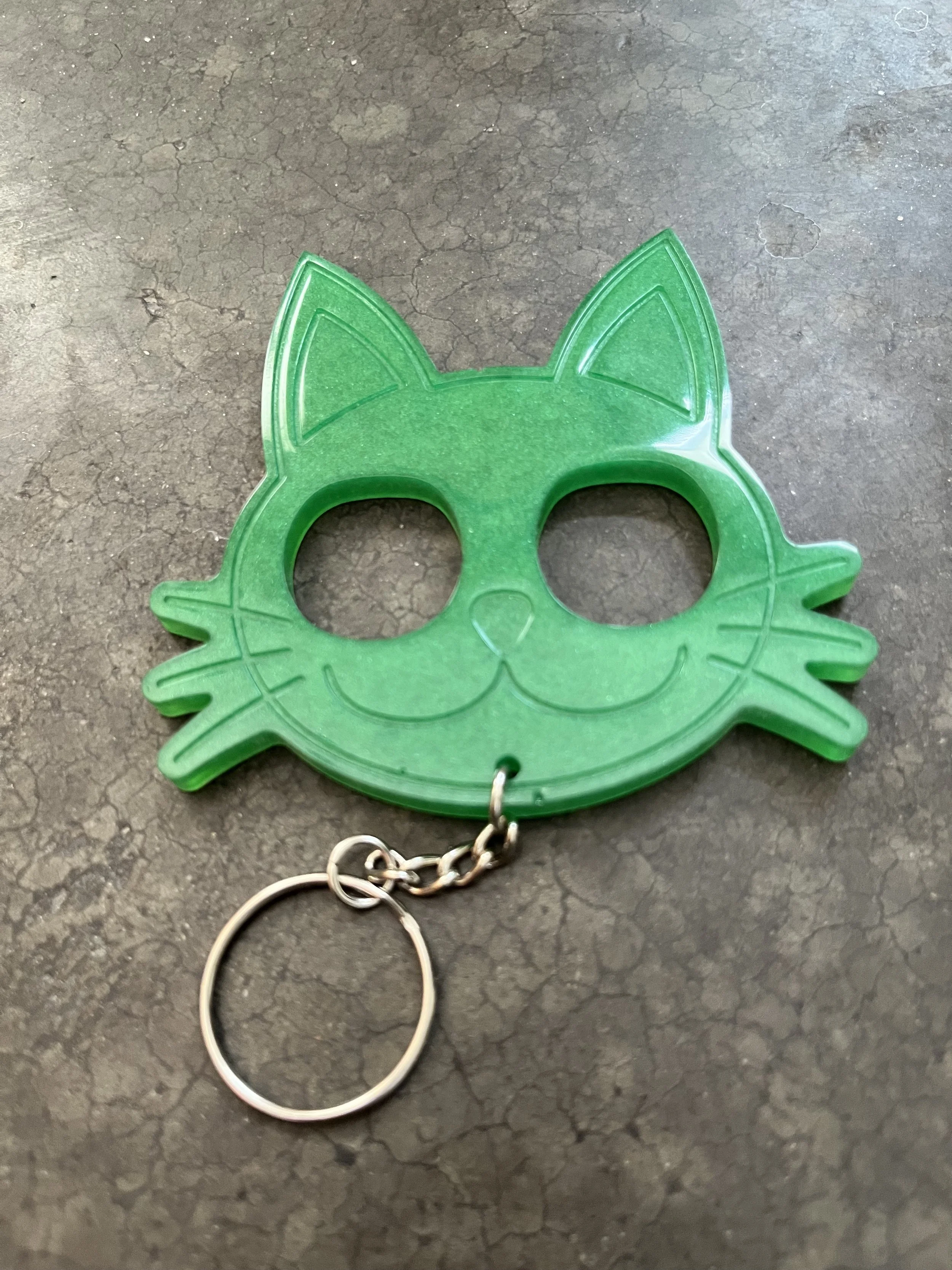 A handmade green cat resin epoxy emergency keychain.