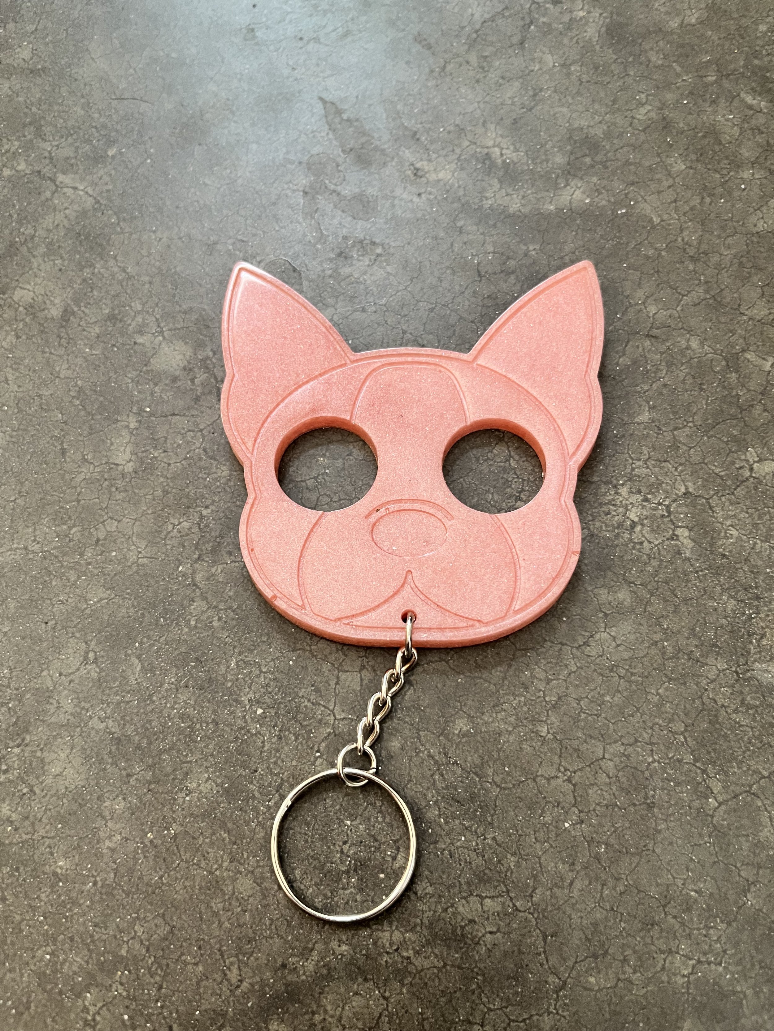 A resin epoxy emergency keychain on a textured gray surface.