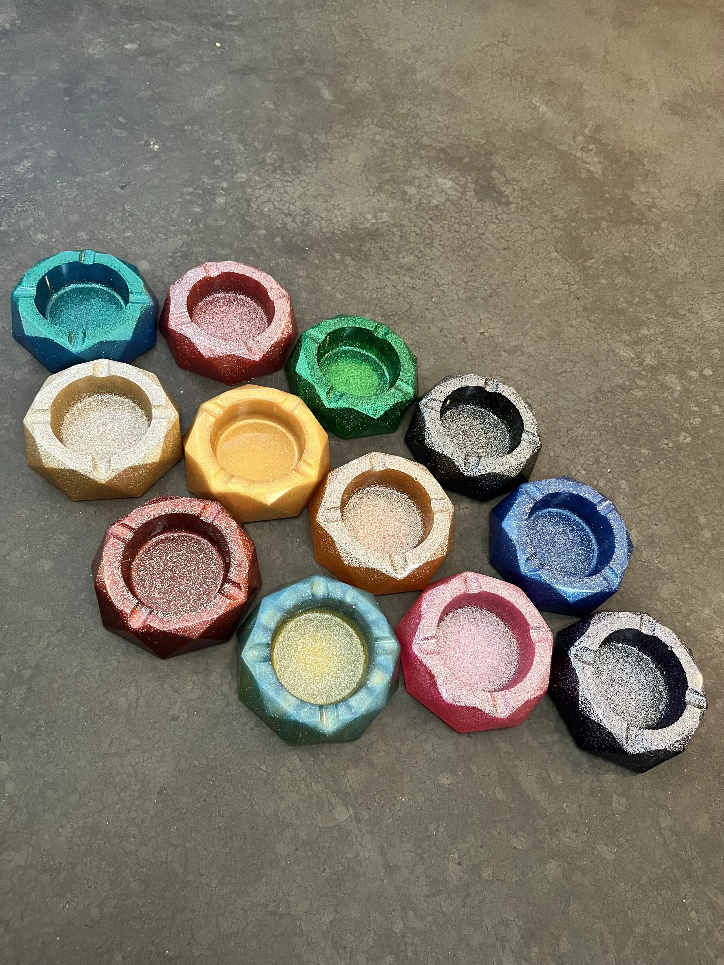 Colorful, glittery, hexagonal-shaped ashtrays/bowls that are handmade.