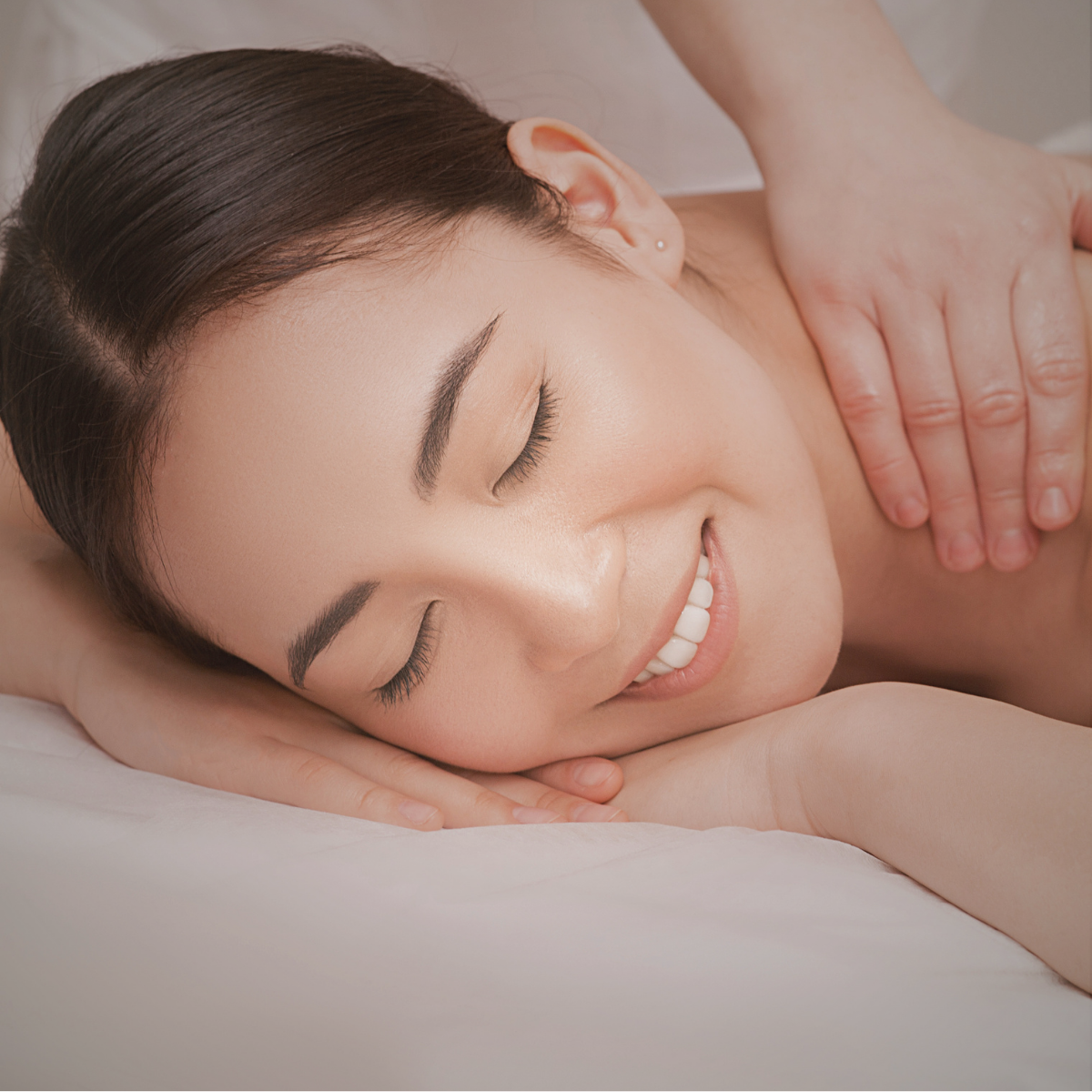 Woman receiving a massage and relaxing with a smile