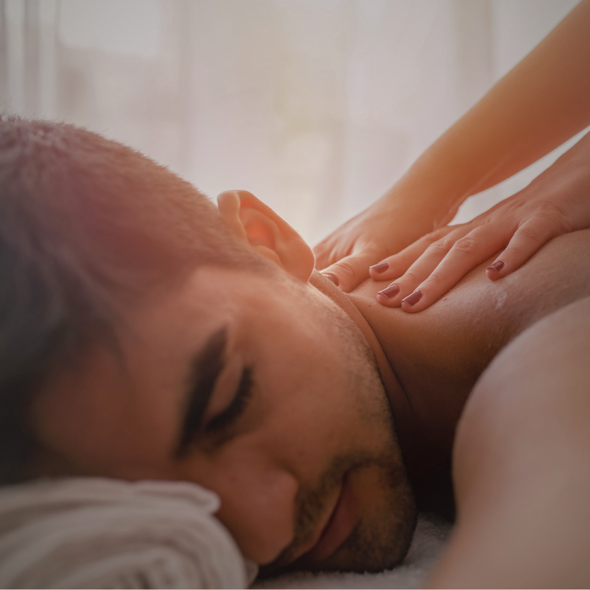 Close-up of a person receiving a massage, lying face down with eyes closed.