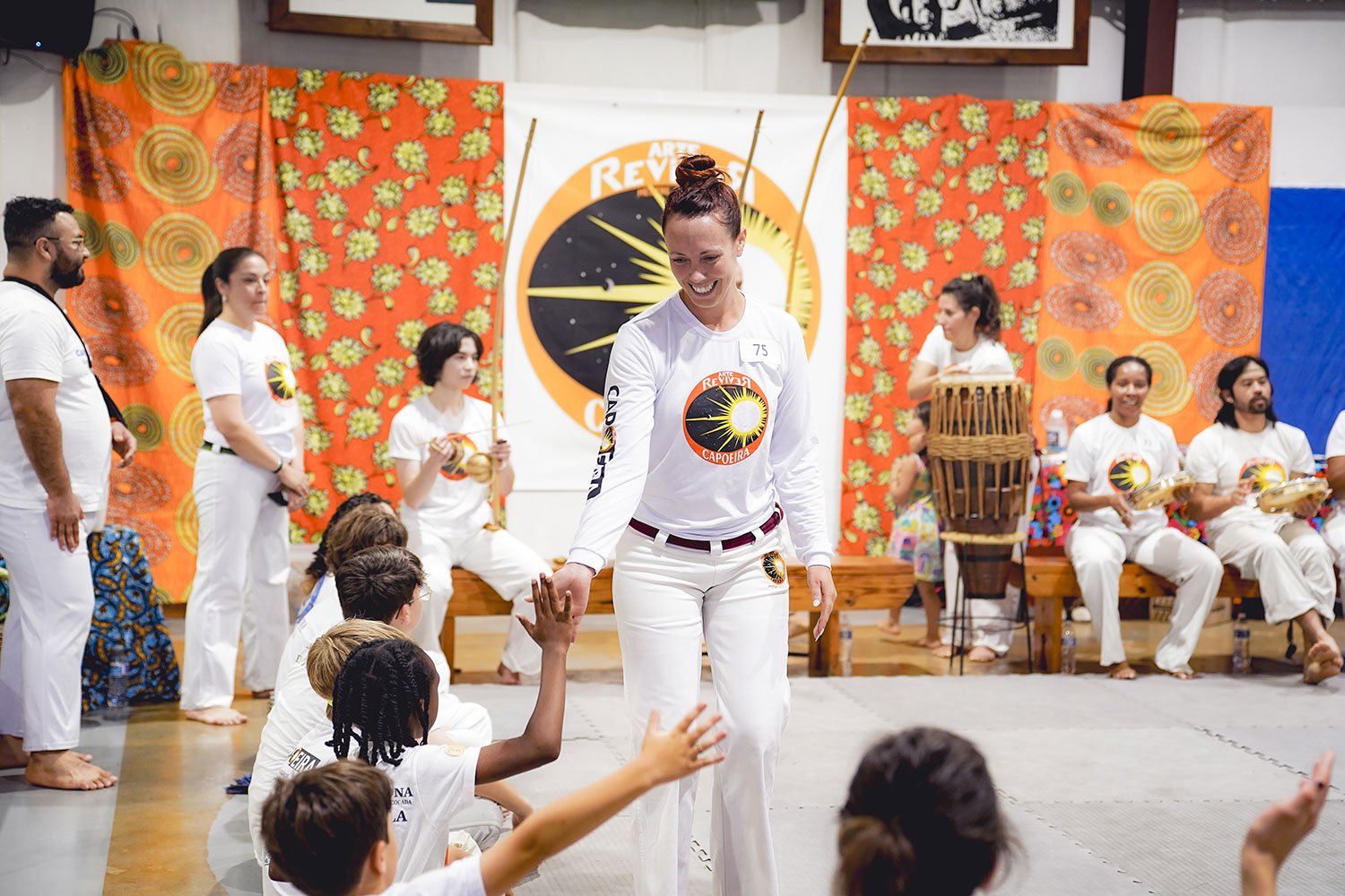 Adult students training Capoeira techniques indoors