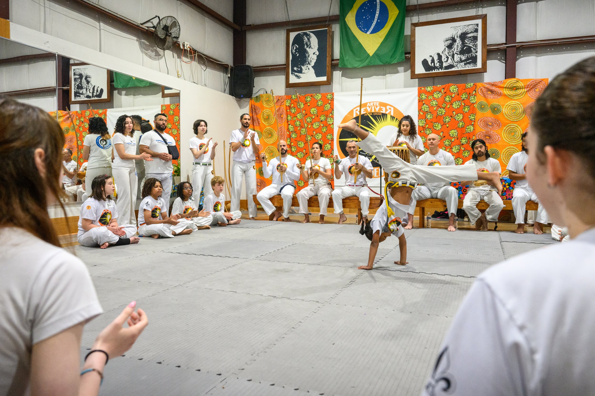 capoeira youth participant doing acrobatic movement in the roda