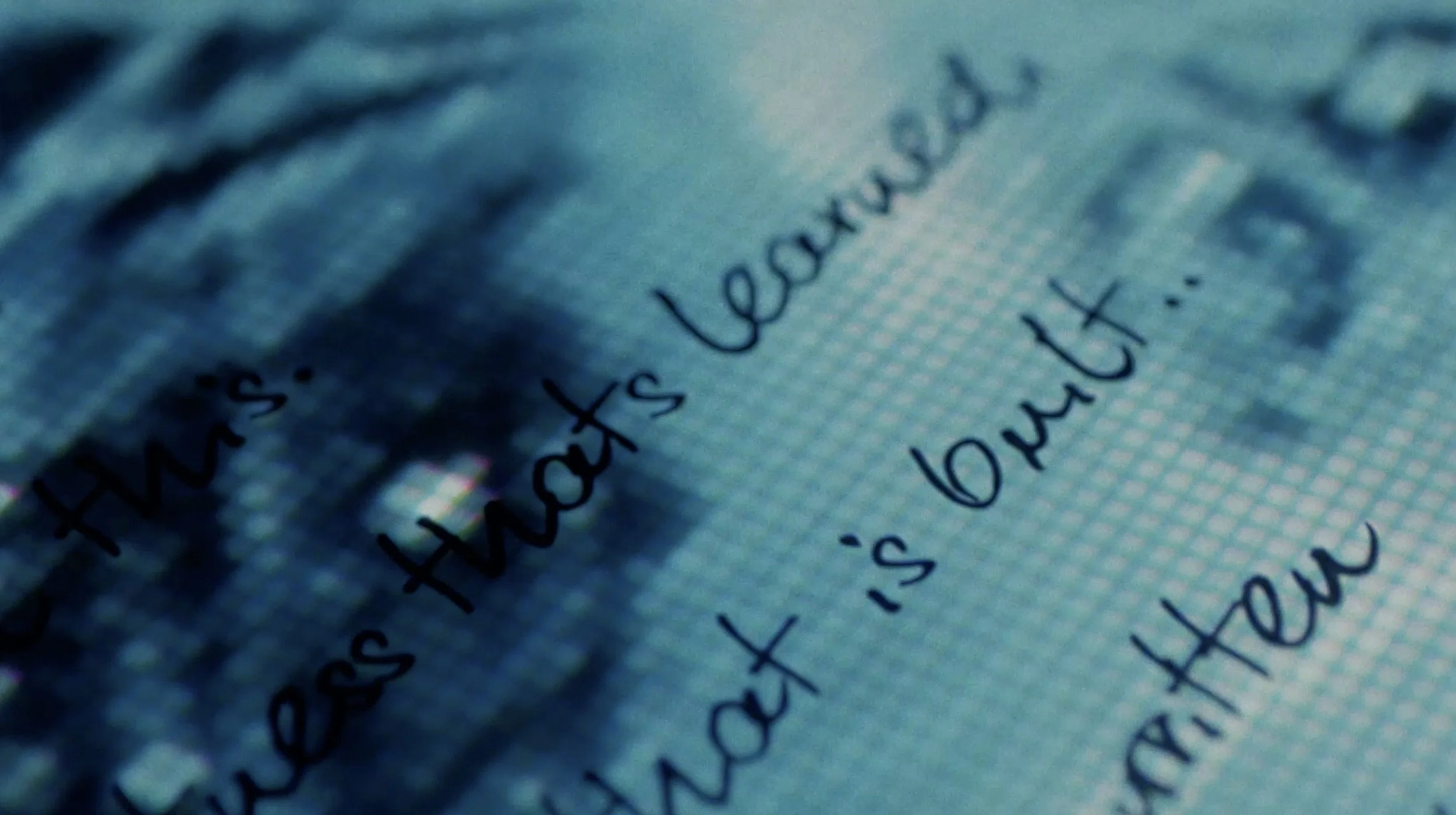 Close-up of a page with handwritten text in black ink on blue paper.