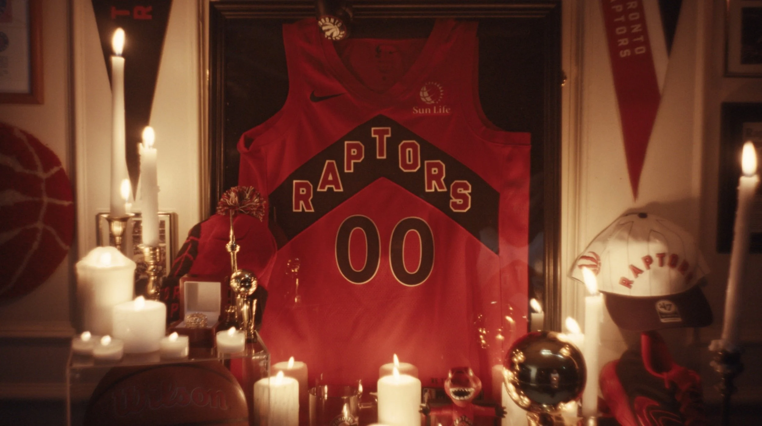 Candles light a shrine that holds a Raptors basketball singlet