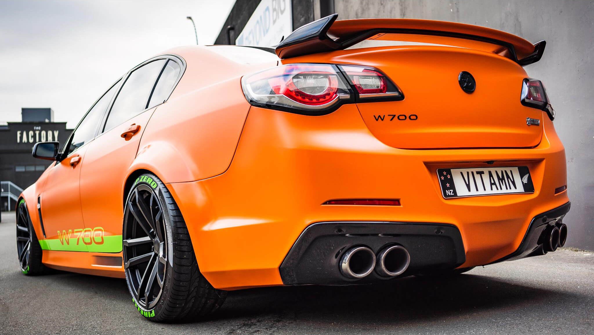 Rear view of premium orange vehicle refinished by West Hamilton