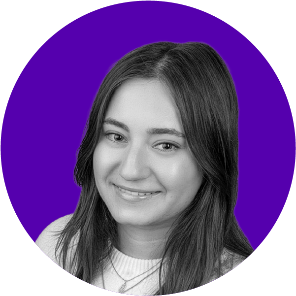 A young woman with long dark hair smiling at the camera, against a purple background.