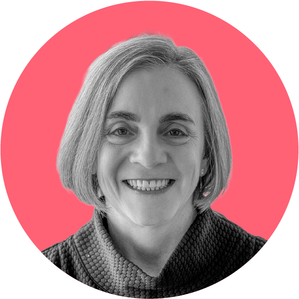 Black and white headshot of a smiling middle-aged woman with short gray hair, wearing a textured top, against a pink circular background.