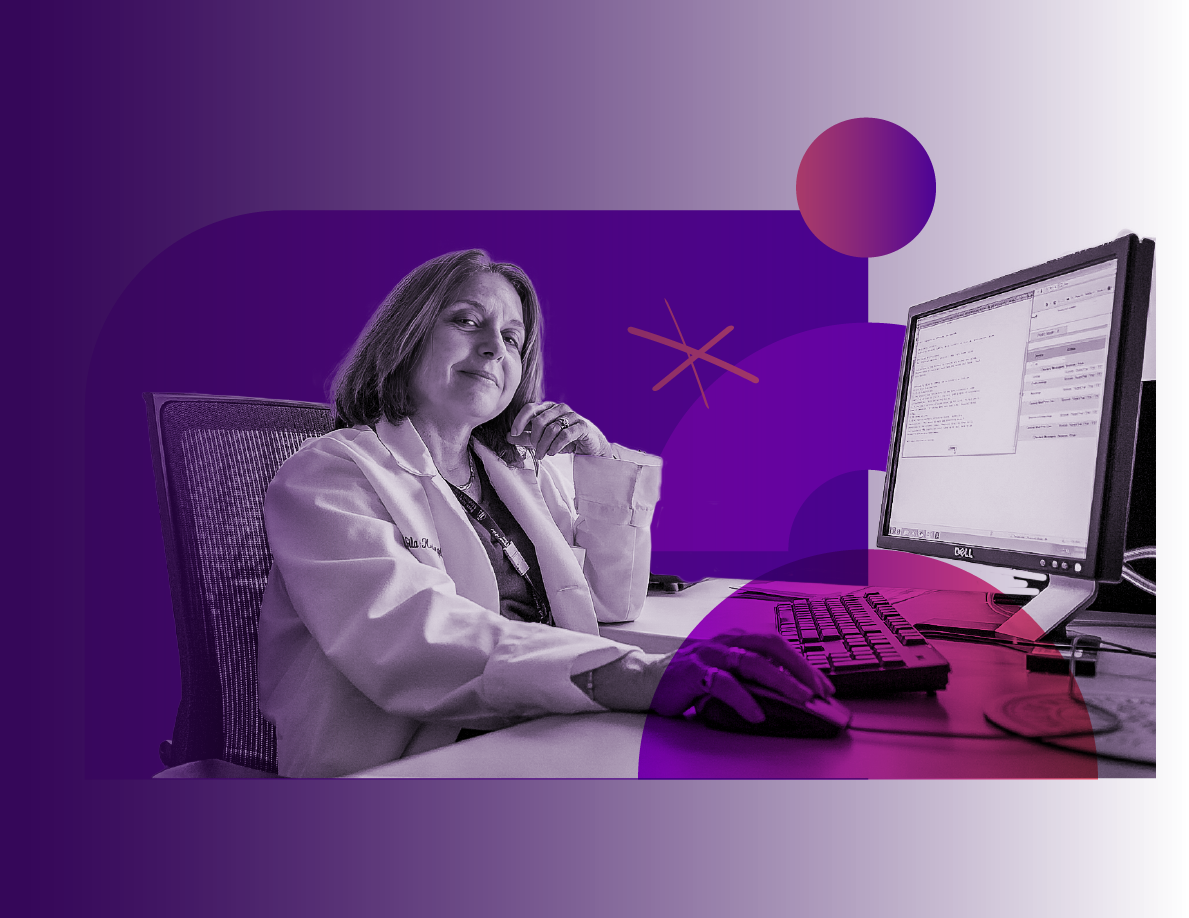 A woman in a white lab coat sitting at a desk with a computer monitor and keyboard, with a purple and pink abstract background.