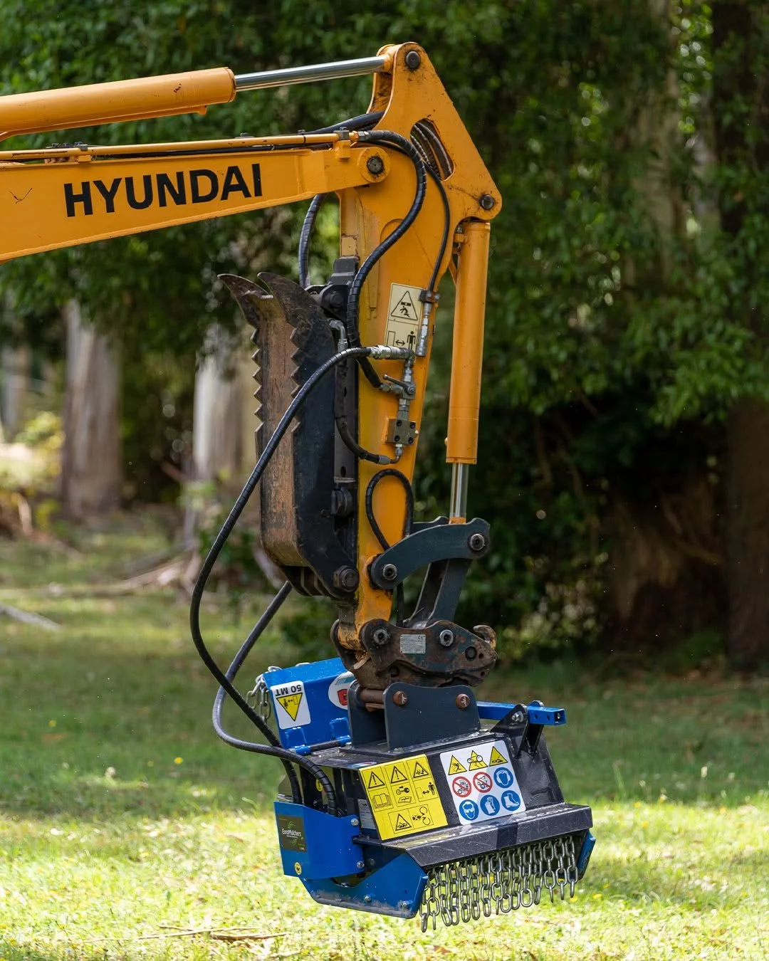Italian-made TFK excavator mulching head processing trees, brush and overgrown vegetation on a land management project.