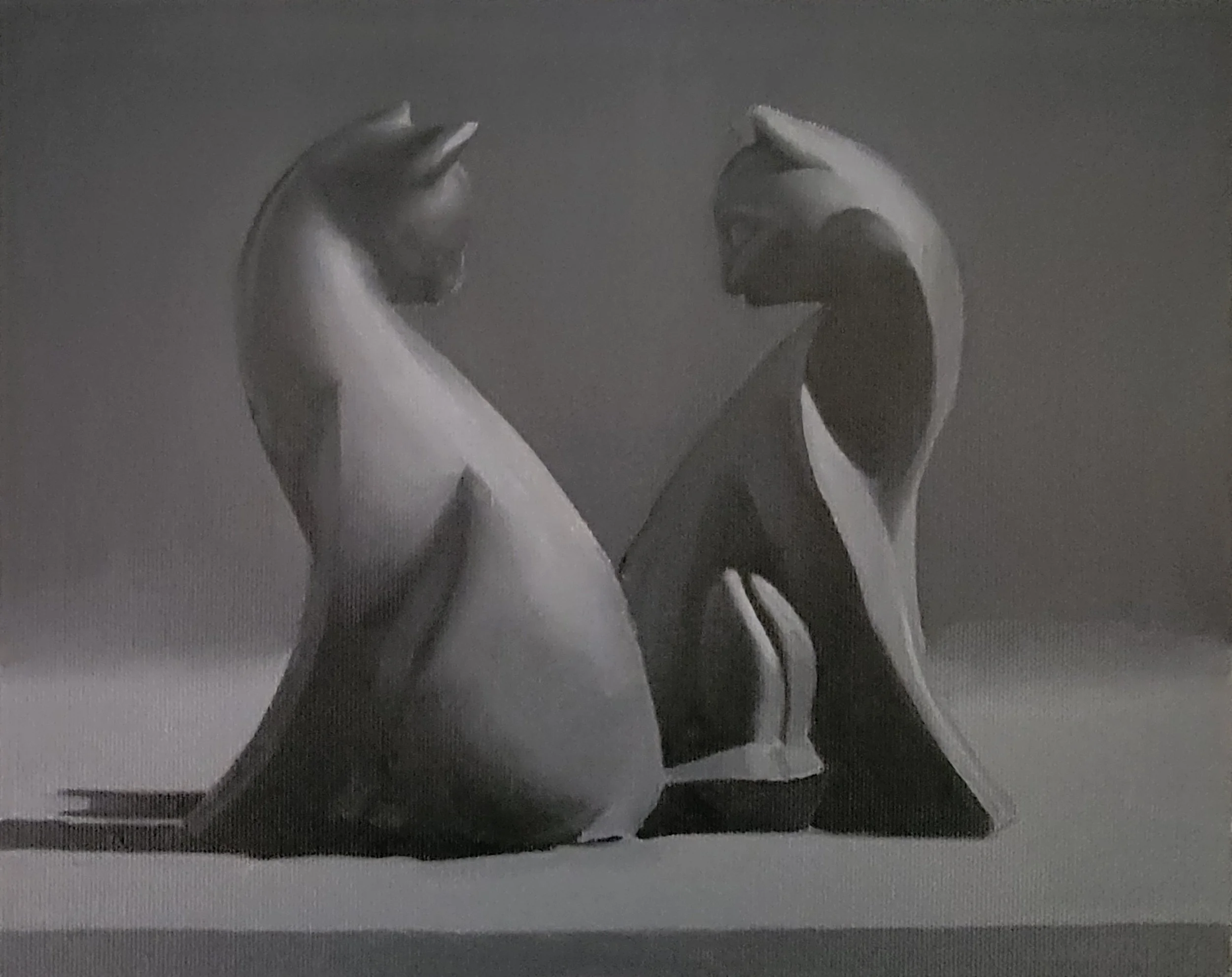 A close-up of a sculpture of two hands with intertwined fingers against a dark background.