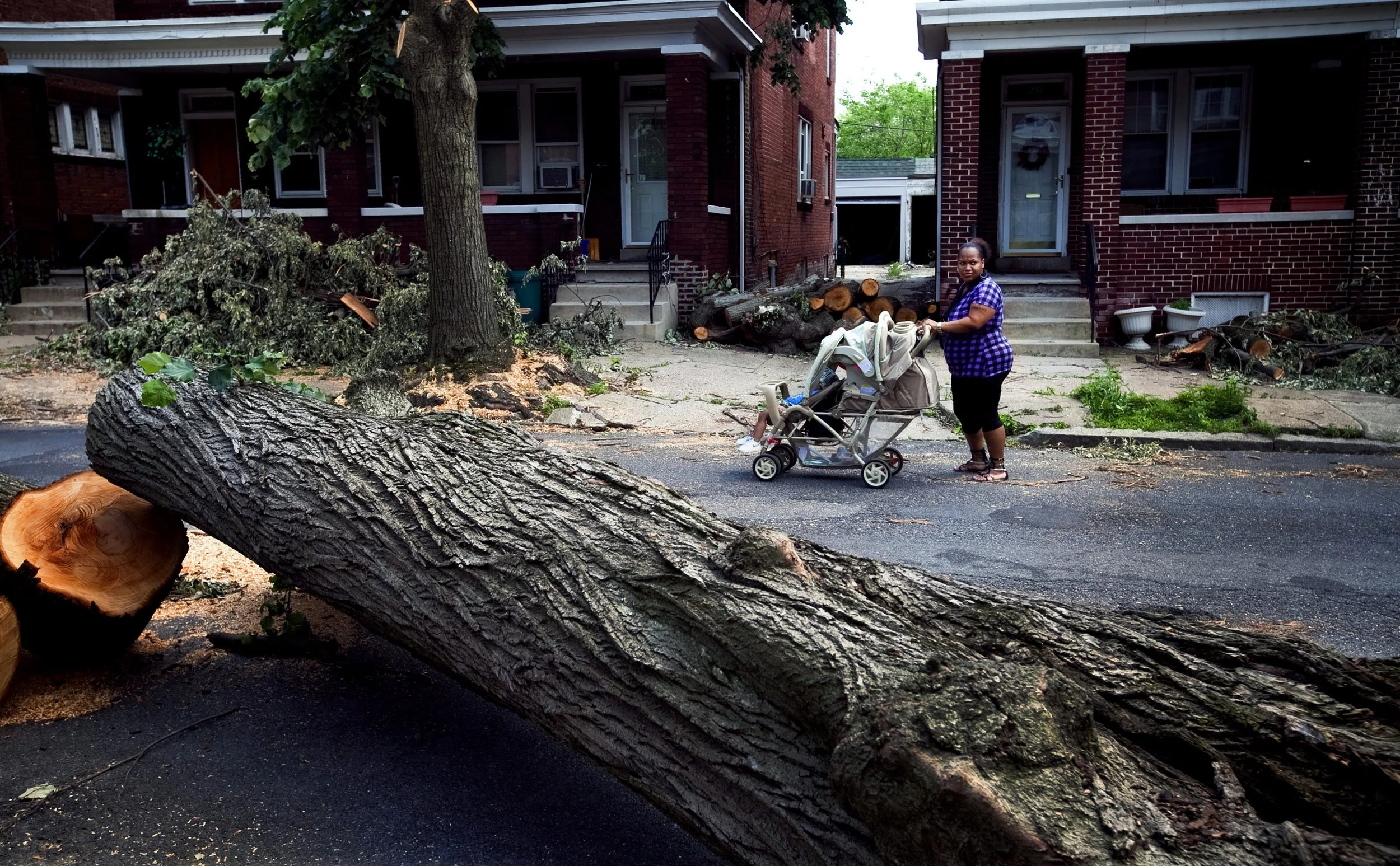 Clarissa Holmes stops to look at the storm damage that moved through the area five days prior as she walks her 2-week-old Samiyah and 18-month-old, Samari to the doctor’s office in Harrisburg, Pa.
