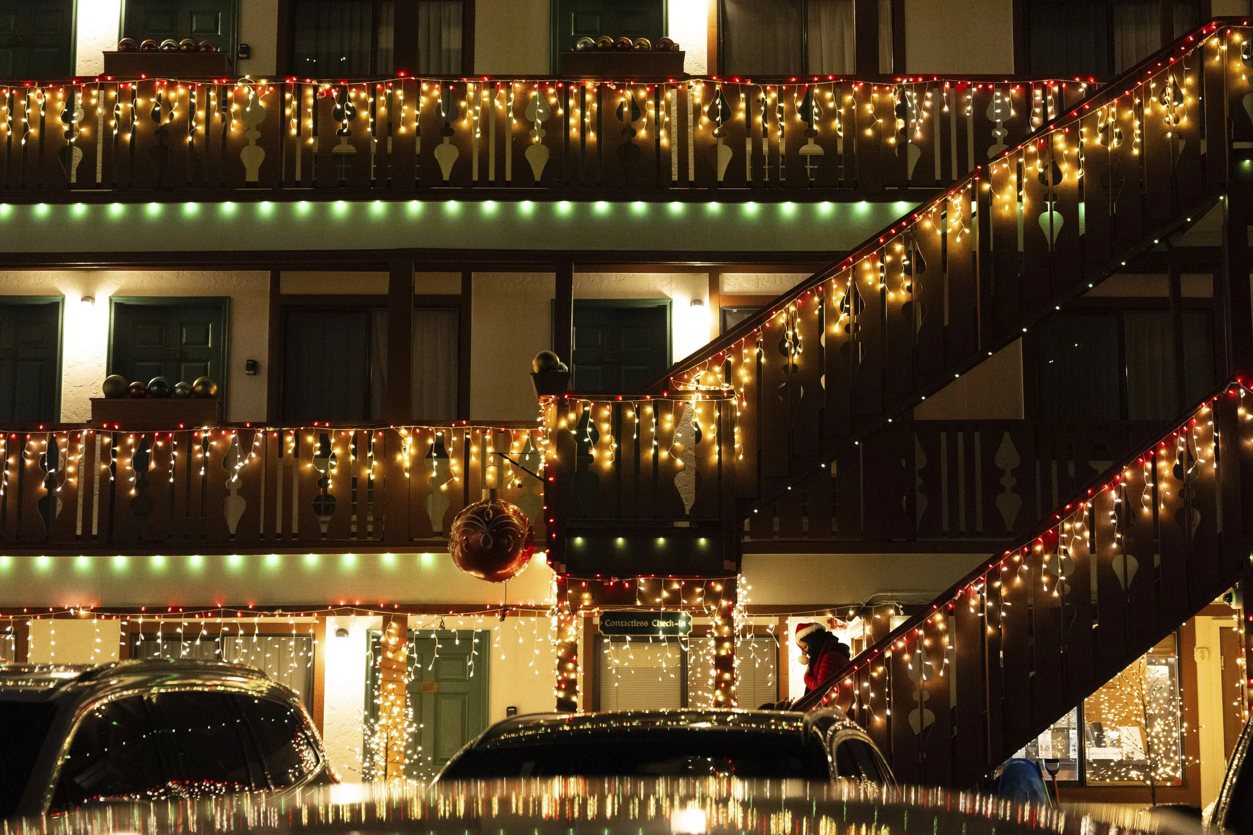 A person wearing a Christmas-themed hat walks down the steps at Obertal Inn on Saturday, Nov. 30, 2024, in Leavenworth, Wash.