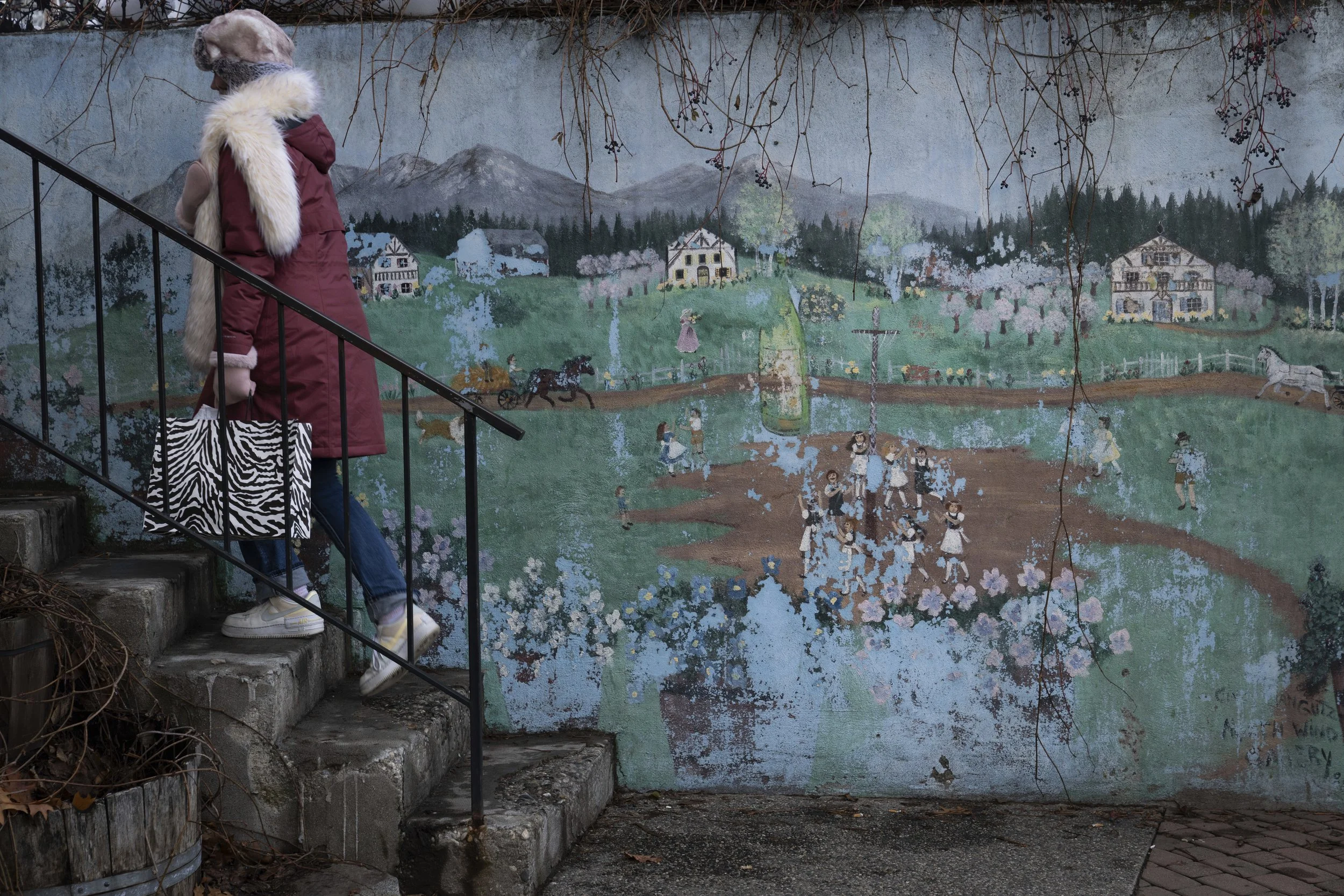 A person walks up steps by a mural on Tuesday, Nov. 26, 2024, in Leavenworth, Wash. 