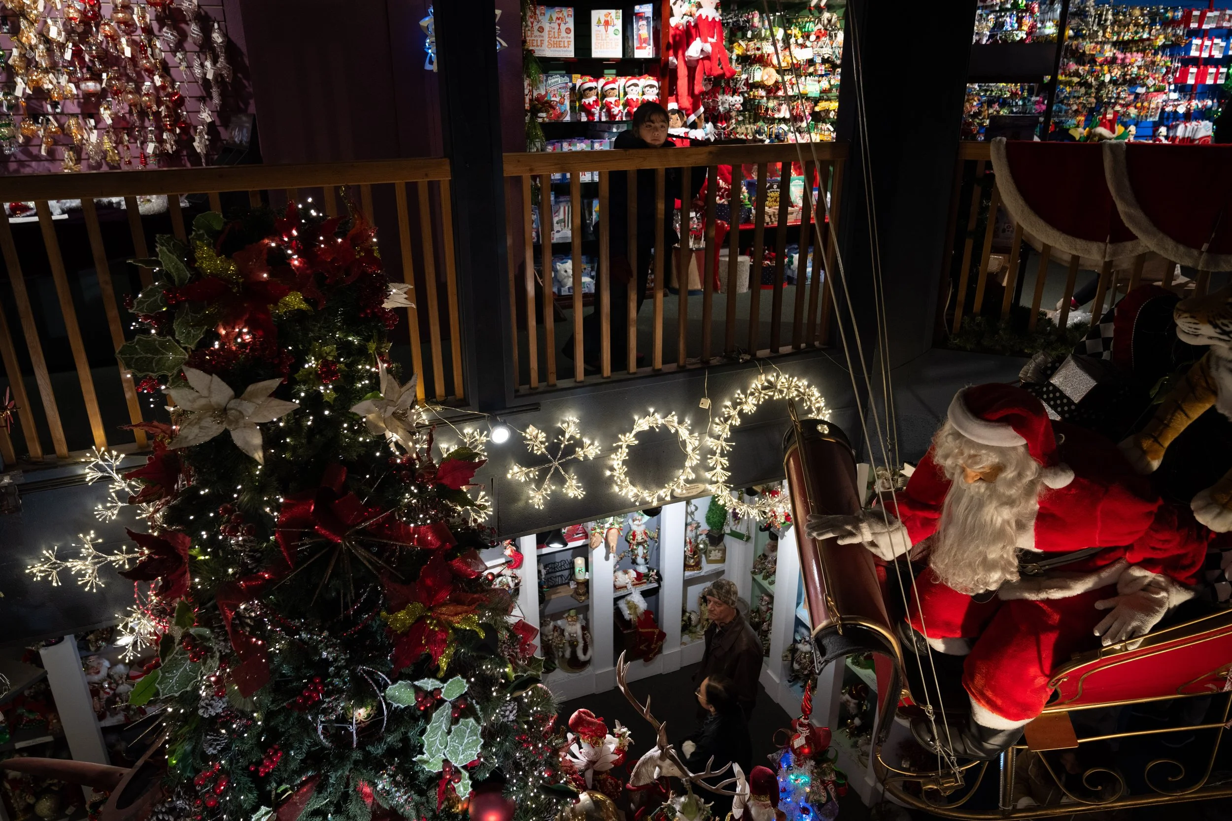 A child looks on from the balcony at a Santa Claus display at Kris Kringl on Tuesday, Nov. 26, 2024, in Leavenworth, Wash.