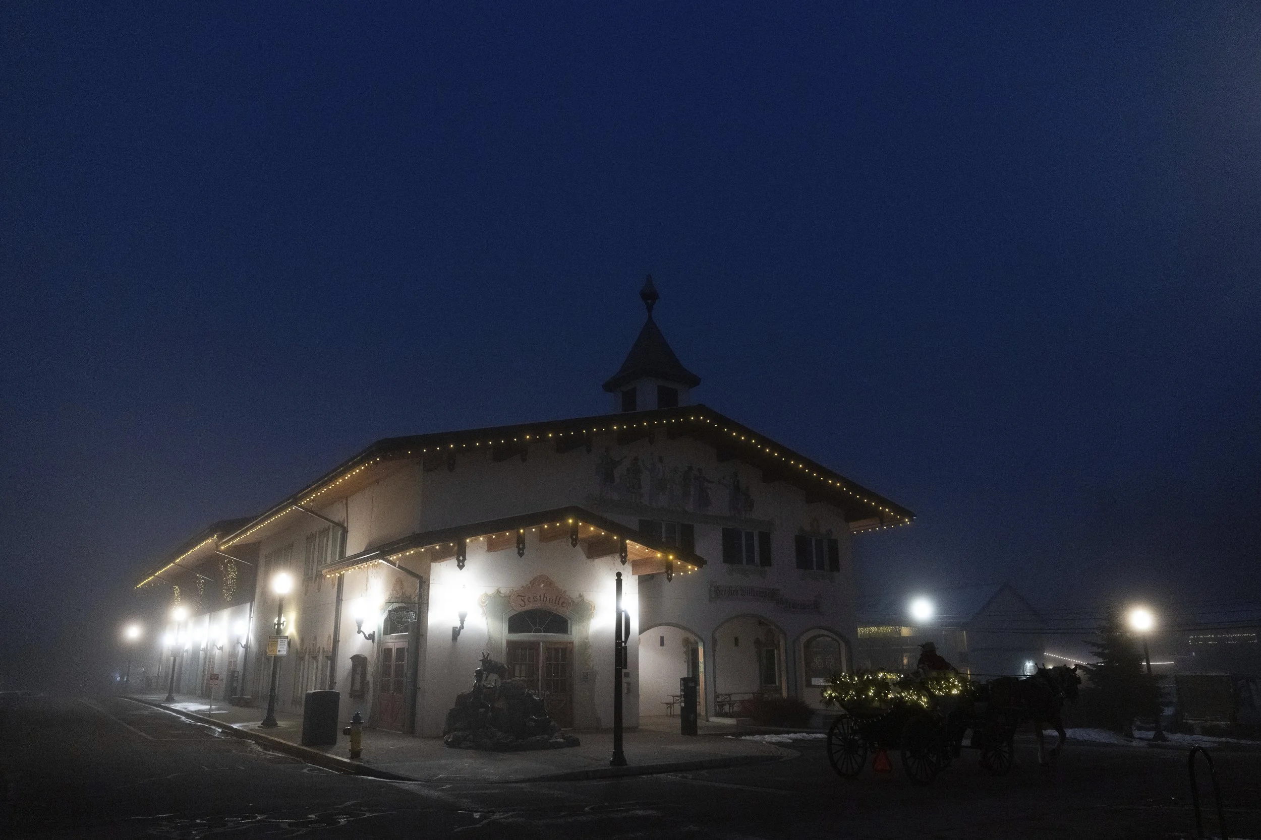 Olav, a Belgian draft horse, pulls a carriage past the Leavenworth Festhalle on Tuesday, Nov. 26, 2024, in Leavenworth, Wash.