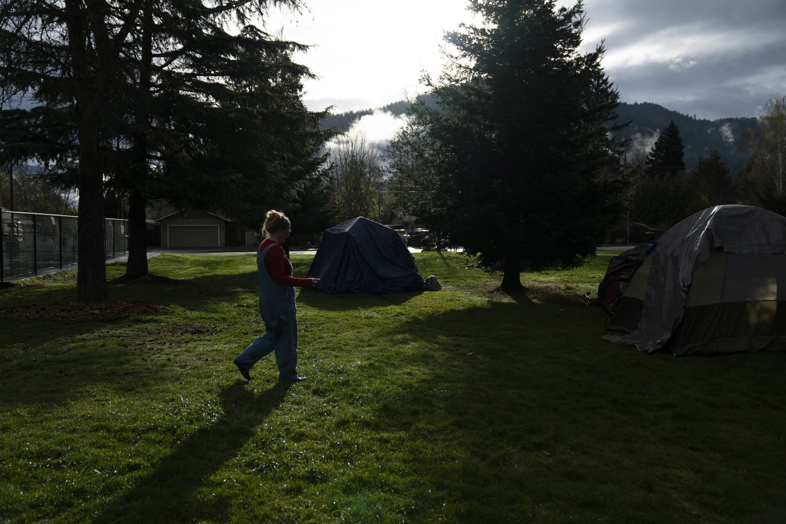 Cassy Leach, a nurse, who leads a group of volunteers who provide food, medical care and other basic goods to the hundreds of homeless people living in the parks, walks to help homeless people camping in Fruitdale Park move their tents on Saturday, M
