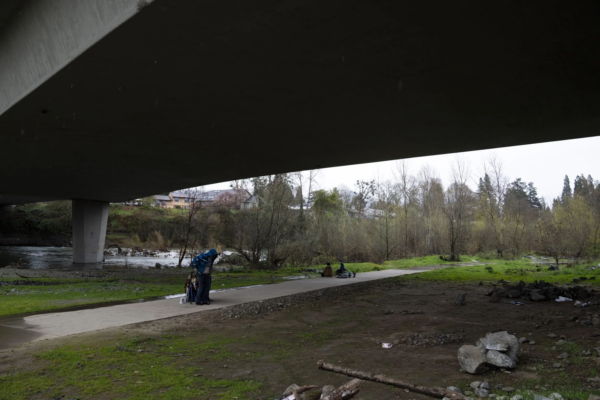 A homeless person adjusts the jacket after receiving it from another under Redwood Highway near Baker Park, Friday, March 22, 2024, in Grants Pass, Ore. The rural city of Grants Pass in southern Oregon became the unlikely face of the nation’s homeles