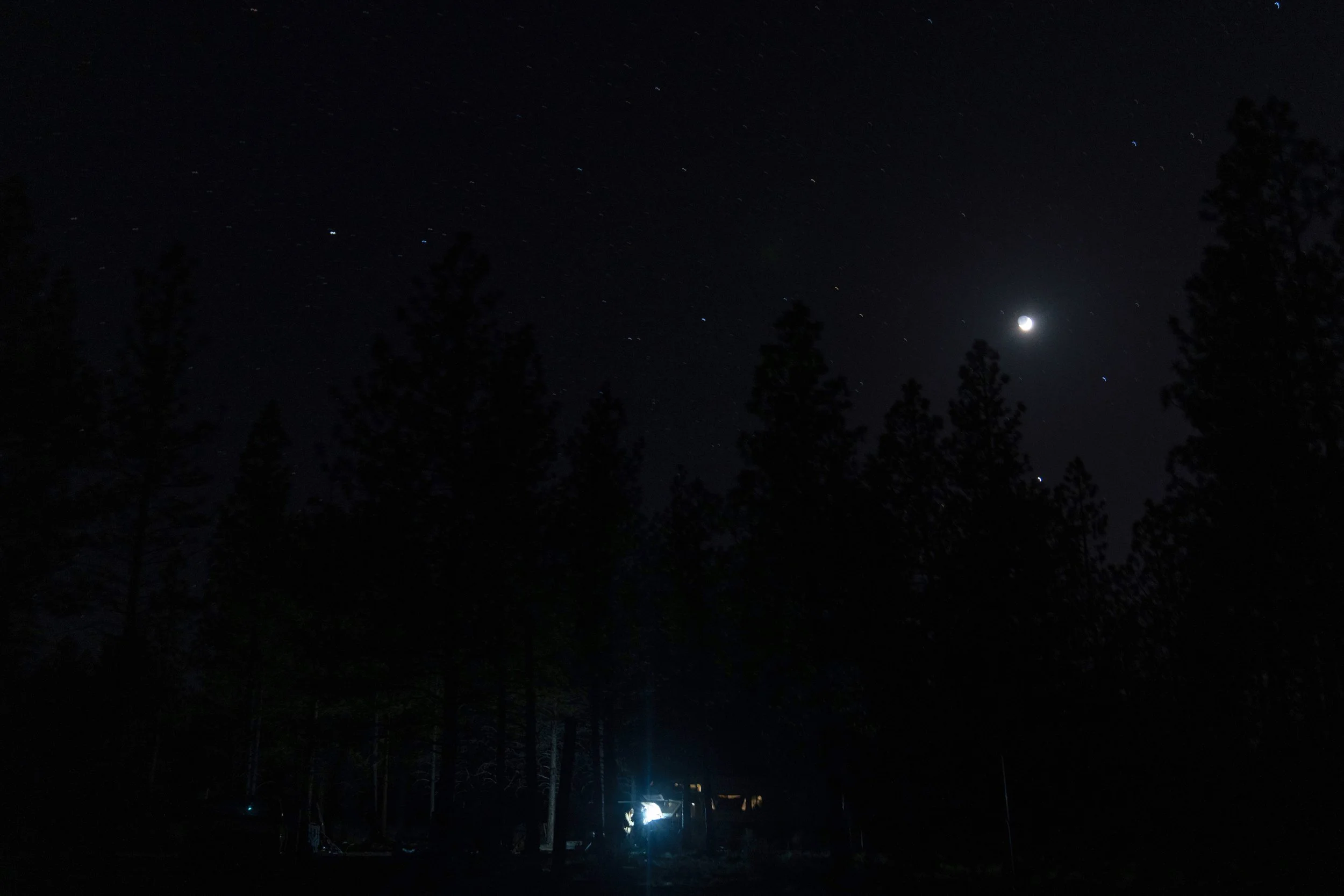 Greg Bishop works to get an RV to start at a homeless encampment in Deschutes National Forest, Wednesday, April 30, 2025 near Bend, Ore.