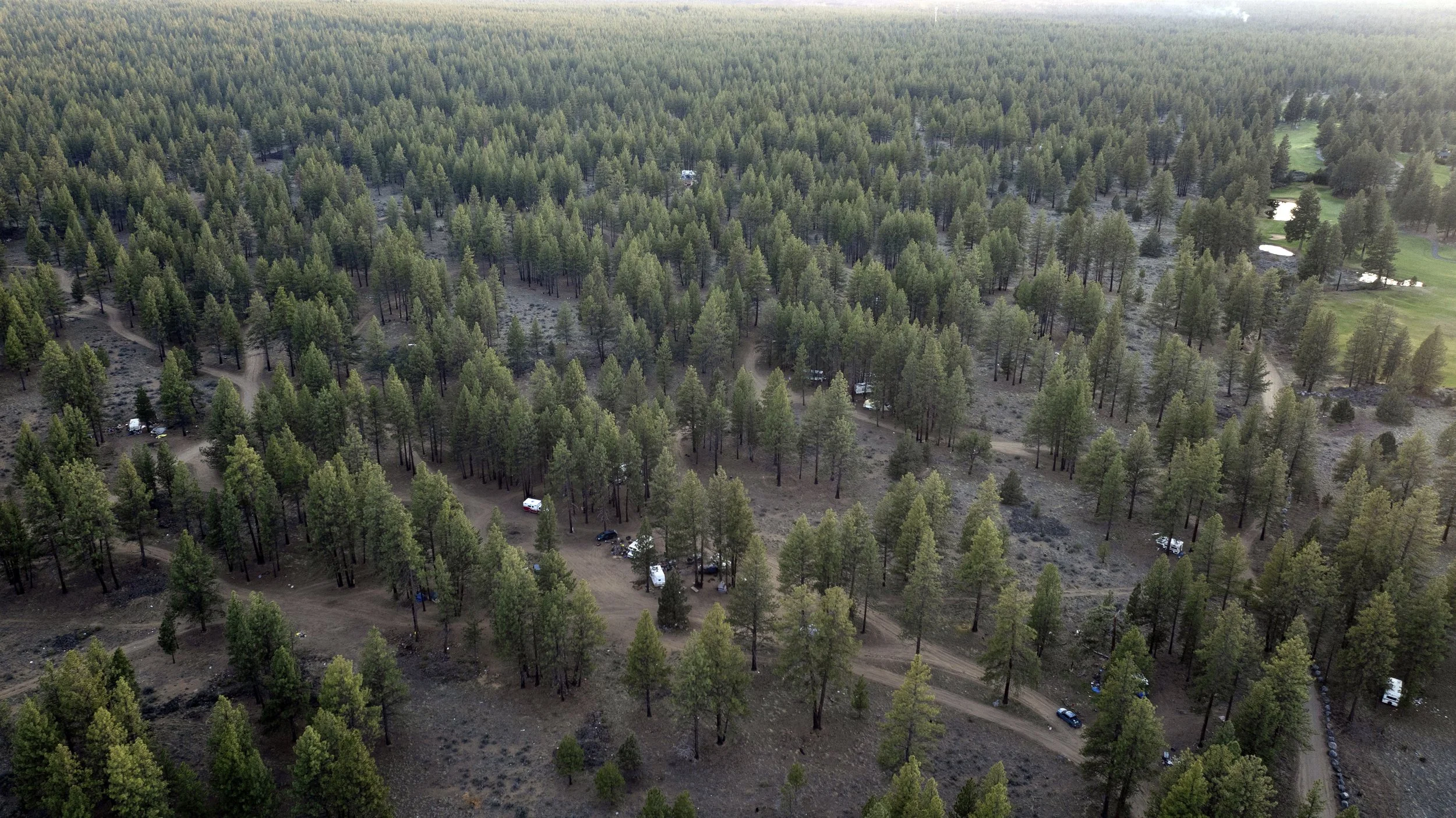 A homeless encampment in Deschutes National Forest is seen near a golf course on the night before an eviction order on Wednesday, April 30, 2025, near Bend, Ore. 