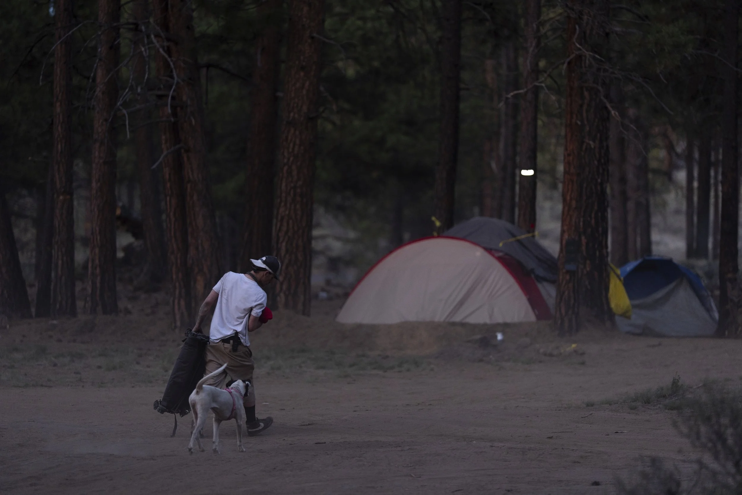 A person walks to a tent at a homeless encampment in Deschutes National Forest, Wednesday, April 30, 2025, near Bend, Ore. 
