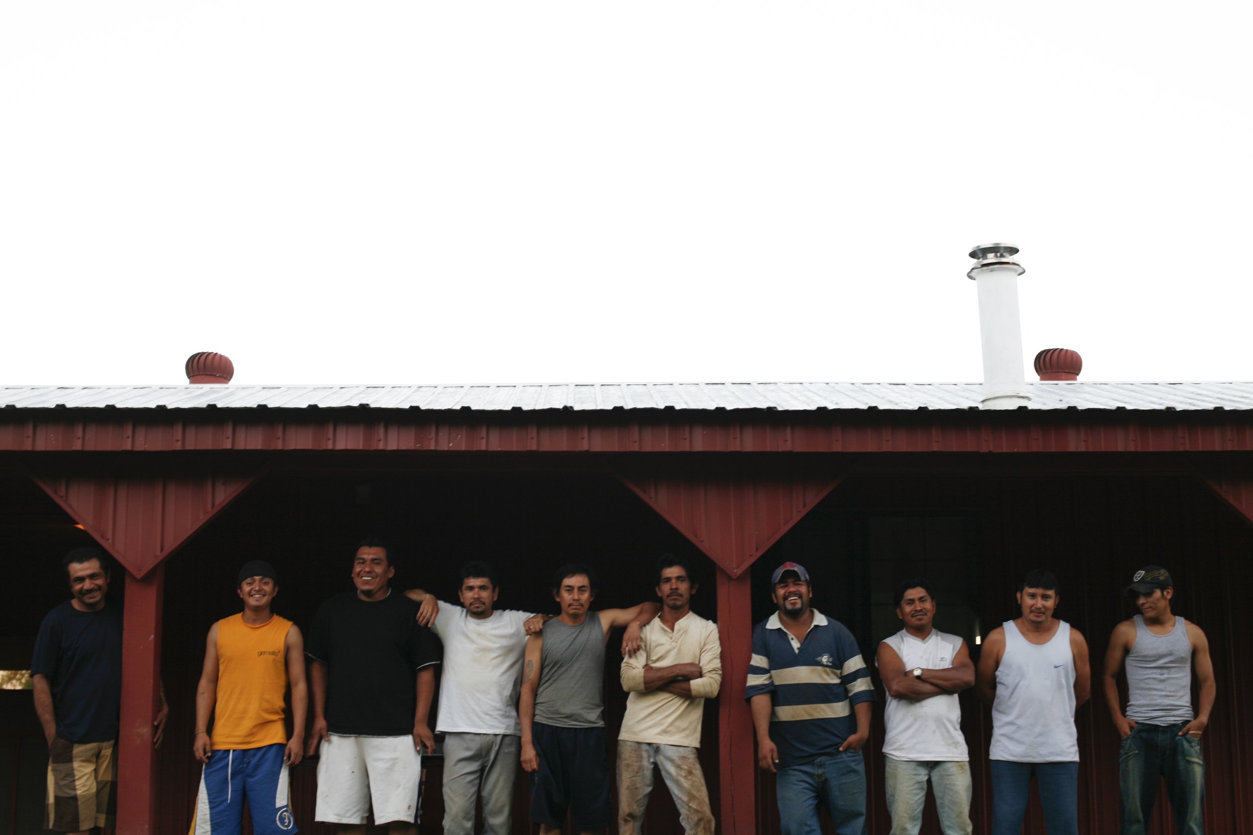 Migrant workers pose for a photo outside their dwelling