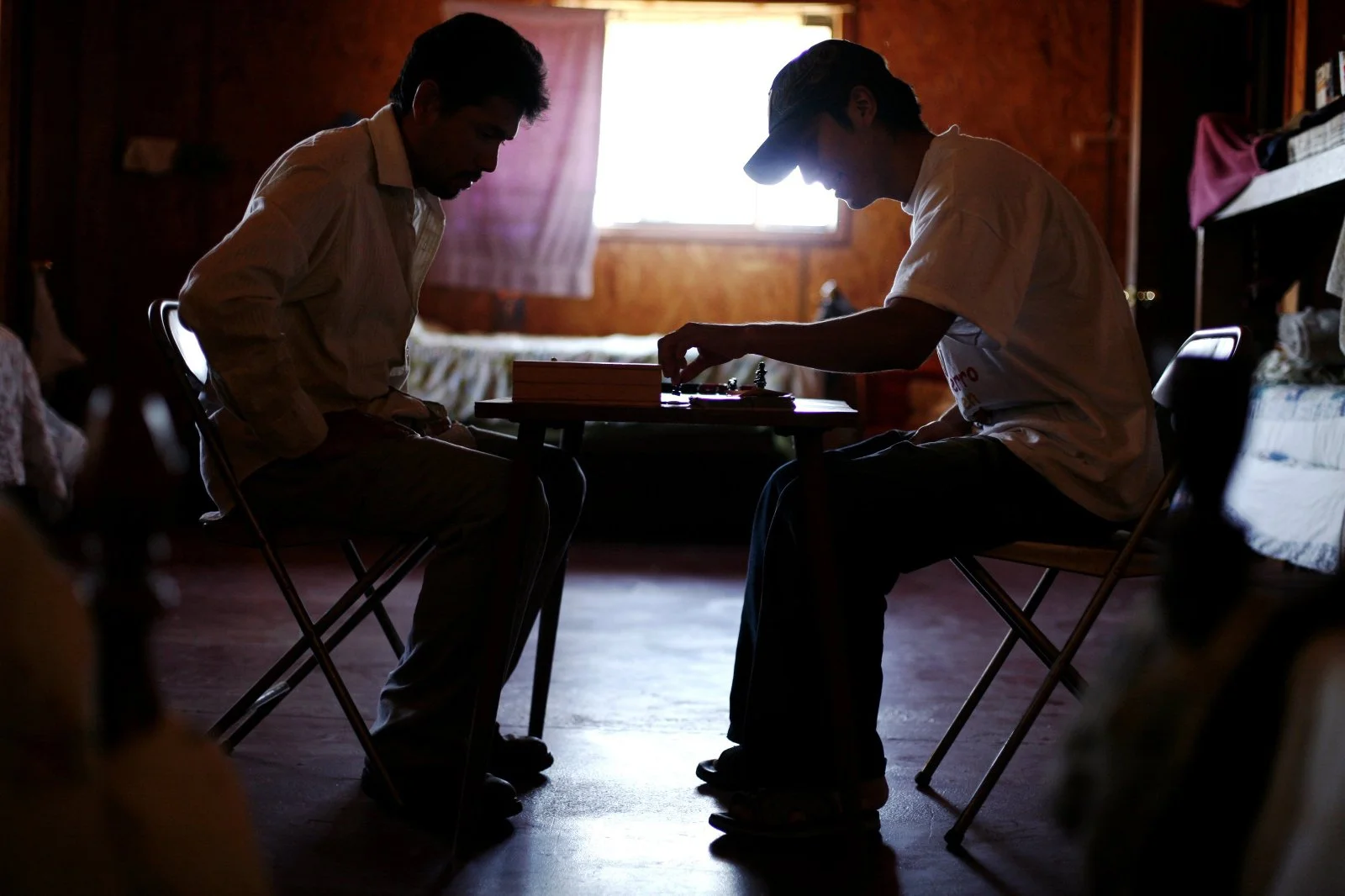 Castillo and Guadalupe use their new chess board given to them by Chad Barber, to replace their smaller one before starting work in the potato fields. Barber occasionally plays with the men. “He my teacher,” said Gaudalupe about Rodriguez.